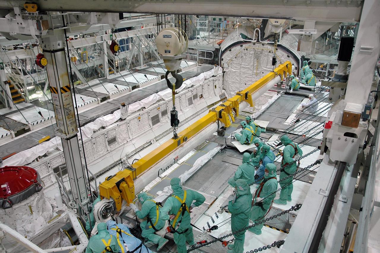 KENNEDY SPACE CENTER, FLA. -  In the Orbiter Processing Facility bay 1 at NASA Kennedy Space Center, engineers finish attaching the remote manipulator system, or boom, in Atlantis’ payload bay.  Atlantis is the designated orbiter for mission STS-115, the 19th assembly flight to the International Space Station.  The payload includes the P3/P4 solar arrays. The launch planning window has not been determined yet for STS-115.