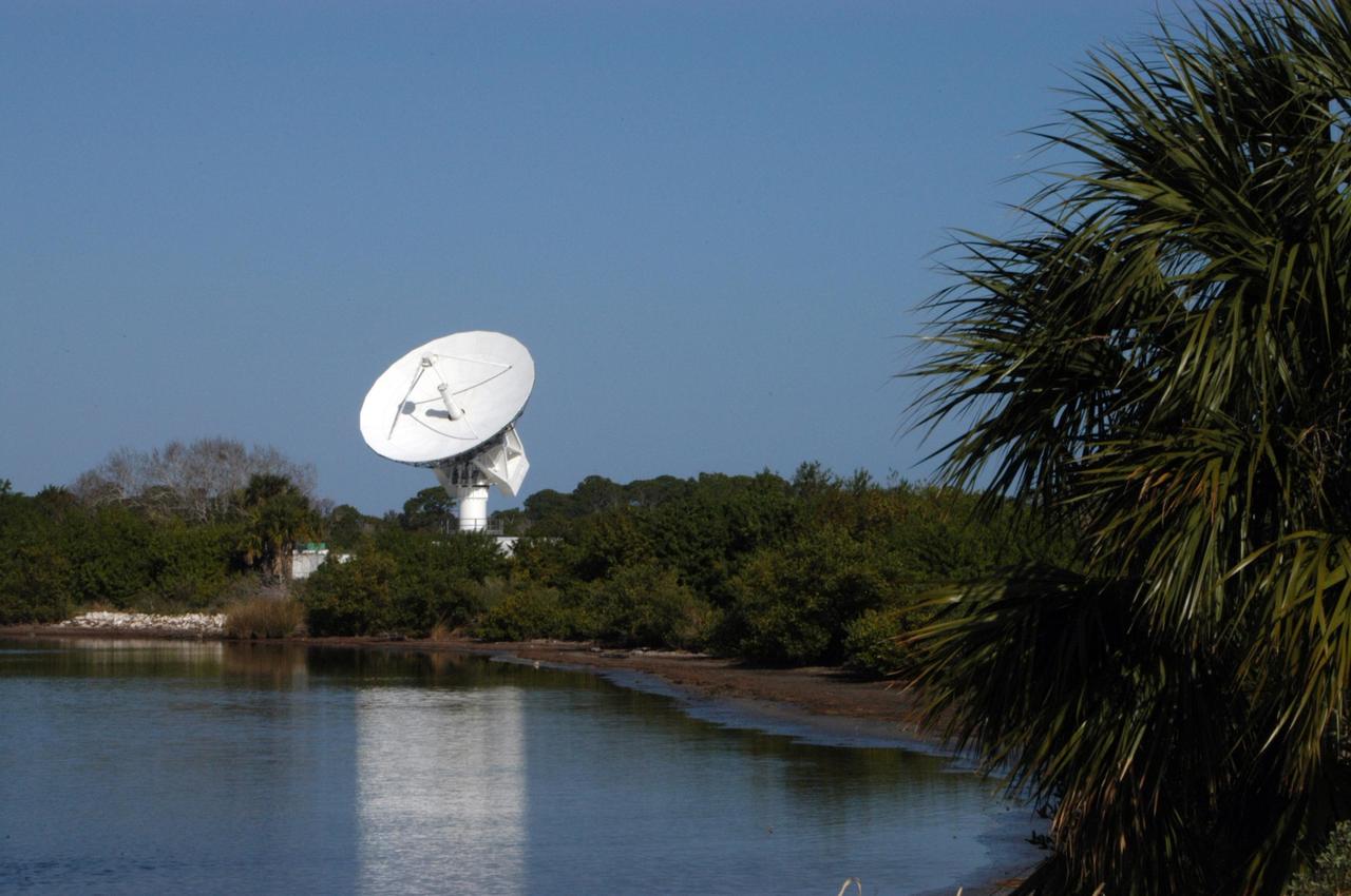 KENNEDY SPACE CENTER, FLA. -  This new C-band, 3 megawatt radar with a 50-foot dish antenna reflects on the marsh water nearby.  The antenna has recently been installed on north Kennedy Space Center.  It is one of the largest of its kind in the world, providing higher definition imagery than has ever been available before.  Working in concert with two new NASA-owned X-band radars mounted on the solid rocket booster retrieval ships, tracking the space shuttle and expendable launch vehicles with this new capability will provide more detail than NASA has ever observed by radar before.  The first use of this C-band radar will be for the launch of the Atlas V rocket sending the New Horizons probe toward Pluto.  The radar is operated under a NASA contract with the U.S. Navy who owns the radar.
