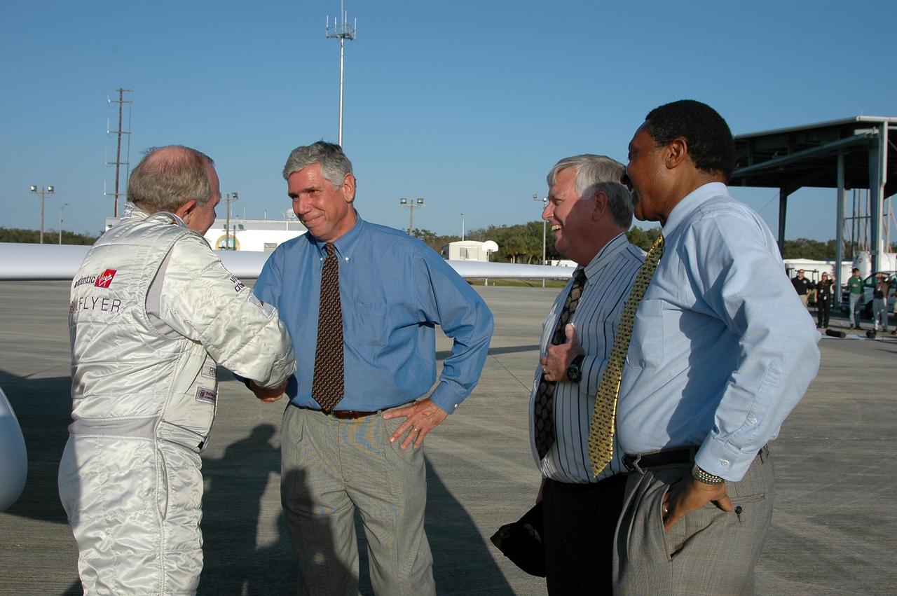 KENNEDY SPACE CENTER, FLA. -   After landing the Virgin Atlantic Airways GlobalFlyer aircraft at NASA Kennedy Space Center’s Shuttle Landing Facility, pilot Steve Fossett is welcomed (left to right) by KSC Spaceport Development Manager Jim Ball, Center Director James Kennedy and Executive Director of Florida Space Authority Winston Scott. The aircraft is being relocated from Salina, Kan., to the Shuttle Landing Facility to begin preparations for an attempt to set a new world record for the longest flight made by any aircraft. An exact takeoff date for the record-setting flight has not been determined and is contingent on weather and jet-stream conditions. The window for the attempt opens in mid-January, making the flight possible anytime between then and the end of February.  NASA agreed to let Virgin Atlantic Airways use Kennedy's Shuttle Landing Facility as a takeoff site. The facility use is part of a pilot program to expand runway access for non-NASA activities.
