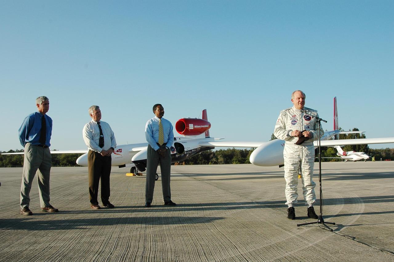 KENNEDY SPACE CENTER, FLA. -  Pilot Steve Fossett talks to the media after his landing of the Virgin Atlantic Airways GlobalFlyer aircraft at NASA Kennedy Space Center’s Shuttle Landing Facility.  Standing at left are KSC Spaceport Development Manager Jim Ball, Center Director James Kennedy and Executive Director of Florida Space Authority Winston Scott. The aircraft is being relocated from Salina, Kan., to the Shuttle Landing Facility to begin preparations for an attempt to set a new world record for the longest flight made by any aircraft. An exact takeoff date for the record-setting flight has not been determined and is contingent on weather and jet-stream conditions. The window for the attempt opens in mid-January, making the flight possible anytime between then and the end of February.  NASA agreed to let Virgin Atlantic Airways use Kennedy's Shuttle Landing Facility as a takeoff site. The facility use is part of a pilot program to expand runway access for non-NASA activities.