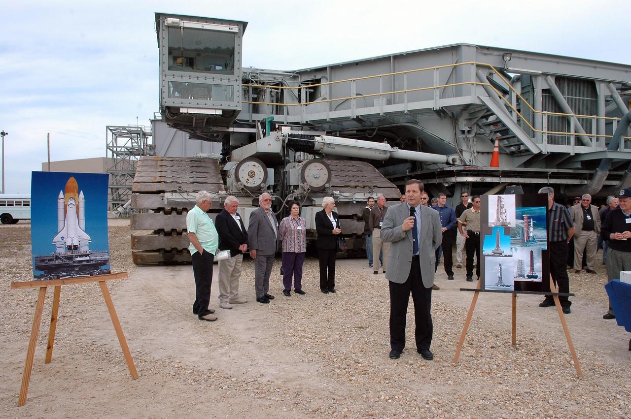 KENNEDY SPACE CENTER, FLA. - Standing in front of one of the crawler transporters at NASA Kennedy Space Center, Director of Space Shuttle Processing Mike Wetmore addresses invited guests (behind him) and the media on the occasion of the 40th anniversary of the crawler transporters. Media representatives and invited guests had the opportunity to tour one of NASA's two crawlers. This included the driver cab and engine room. Guests included current drivers and operators, as well as drivers from the Apollo Program. In January 1966, the crawler completed its first successful move with a 10.6-million-pound launch umbilical tower. It moved three-quarters of a mile in about nine hours. Throughout 40 years of service, the two crawlers have moved more than 3,500 miles and carried seven vehicles.
