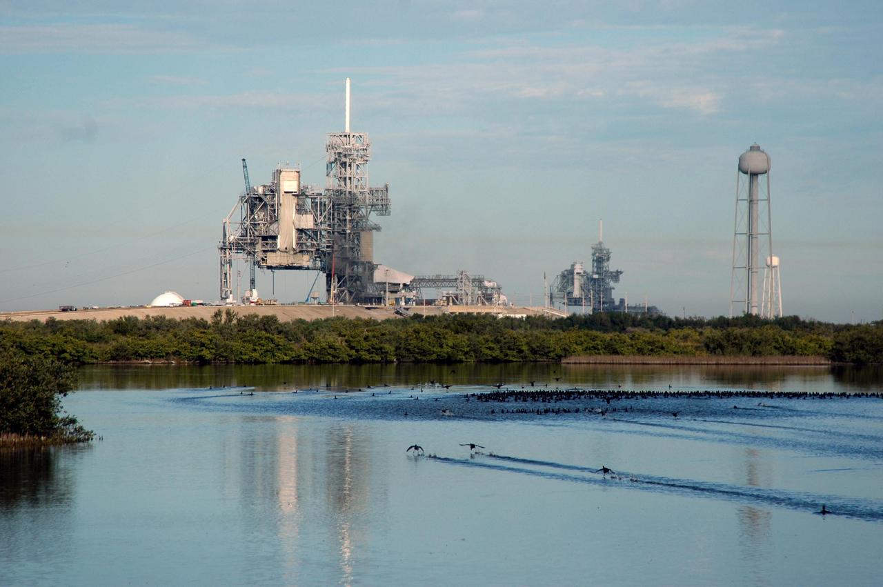KENNEDY SPACE CENTER, FLA. -  Viewed from the east side, Launch Pads 39A and 39B tower over the bird-filled waters of the Banana River at NASA Kennedy Space Center.  On the far right is seen the 300-gallon water tower.  Rising above the fixed service structures are the 80-foot lightning masts that help protect the structures from lightning strikes.