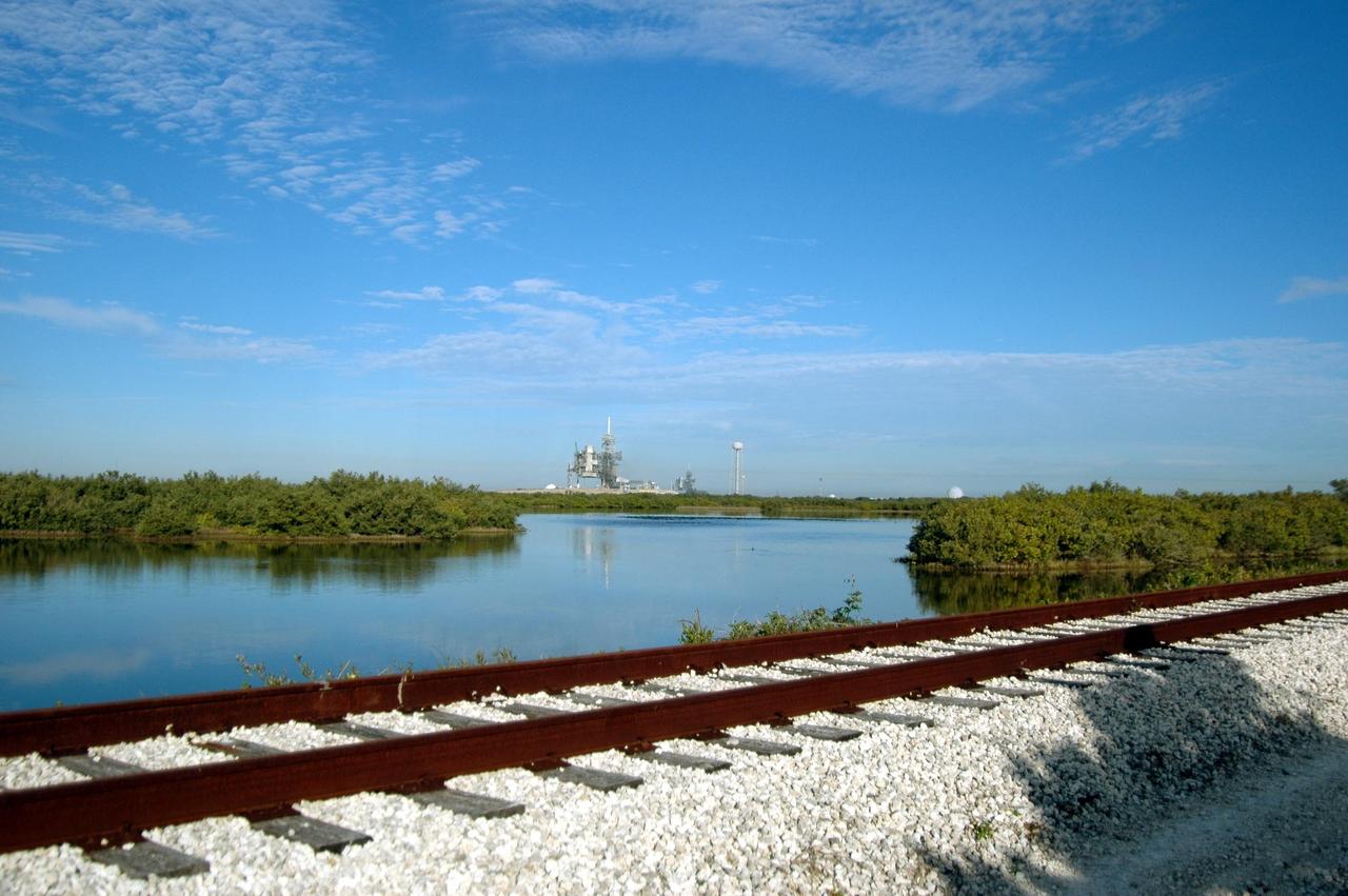 KENNEDY SPACE CENTER, FLA. -  Railroad tracks run along the shoreline east of Launch Pads 39A and 39B, seen in the background.  North of Launch Pad 39B, the tracks turn west, passing the KSC Shuttle Landing Facility and heading through the Merritt Island National Wildlife Refuge until joining the East Coast Railway north of Titusville, Fla.