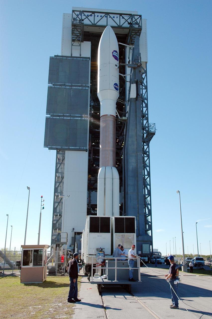 KENNEDY SPACE CENTER, FLA. -  On Complex 41 at Cape Canaveral Air Force Station, the Atlas V expendable launch vehicle with the New Horizons spacecraft rolls out of the Vertical Integration Facility on its way to the launch pad. The liftoff is scheduled for 1:24 p.m. EST Jan. 17.  After its launch aboard the Atlas V, the compact, 1,050-pound piano-sized probe will get a boost from a kick-stage solid propellant motor for its journey to Pluto. New Horizons will be the fastest spacecraft ever launched, reaching lunar orbit distance in just nine hours and passing Jupiter 13 months later. The New Horizons science payload, developed under direction of Southwest Research Institute, includes imaging infrared and ultraviolet spectrometers, a multi-color camera, a long-range telescopic camera, two particle spectrometers, a space-dust detector and a radio science experiment. The dust counter was designed and built by students at the University of Colorado, Boulder. A launch before Feb. 3 allows New Horizons to fly past Jupiter in early 2007 and use the planet’s gravity as a slingshot toward Pluto. The Jupiter flyby trims the trip to Pluto by as many as five years and provides opportunities to test the spacecraft’s instruments and flyby capabilities on the Jupiter system. New Horizons could reach the Pluto system as early as mid-2015, conducting a five-month-long study possible only from the close-up vantage of a spacecraft.