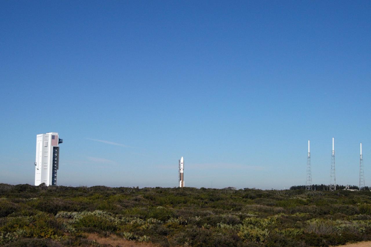 KENNEDY SPACE CENTER, FLA. - On Complex 41 at Cape Canaveral Air Force Station, the Atlas V expendable launch vehicle with the New Horizons spacecraft moves with the launcher umbilical tower to the pad. The liftoff is scheduled for 1:24 p.m. EST Jan. 17. After its launch aboard the Atlas V, the compact, 1,050-pound piano-sized probe will get a boost from a kick-stage solid propellant motor for its journey to Pluto. New Horizons will be the fastest spacecraft ever launched, reaching lunar orbit distance in just nine hours and passing Jupiter 13 months later. The New Horizons science payload, developed under direction of Southwest Research Institute, includes imaging infrared and ultraviolet spectrometers, a multi-color camera, a long-range telescopic camera, two particle spectrometers, a space-dust detector and a radio science experiment. The dust counter was designed and built by students at the University of Colorado, Boulder. A launch before Feb. 3 allows New Horizons to fly past Jupiter in early 2007 and use the planet’s gravity as a slingshot toward Pluto. The Jupiter flyby trims the trip to Pluto by as many as five years and provides opportunities to test the spacecraft’s instruments and flyby capabilities on the Jupiter system. New Horizons could reach the Pluto system as early as mid-2015, conducting a five-month-long study possible only from the close-up vantage of a spacecraft.