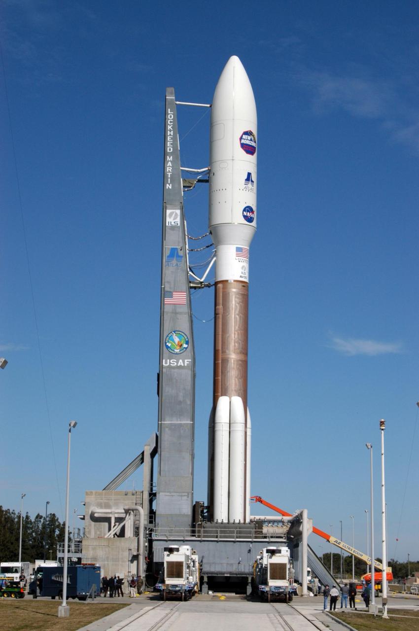KENNEDY SPACE CENTER, FLA. - On Complex 41 at Cape Canaveral Air Force Station, the Atlas V expendable launch vehicle with the New Horizons spacecraft settles into position with the launcher umbilical tower on the pad. The liftoff is scheduled for 1:24 p.m. EST Jan. 17. After its launch aboard the Atlas V, the compact, 1,050-pound piano-sized probe will get a boost from a kick-stage solid propellant motor for its journey to Pluto. New Horizons will be the fastest spacecraft ever launched, reaching lunar orbit distance in just nine hours and passing Jupiter 13 months later. The New Horizons science payload, developed under direction of Southwest Research Institute, includes imaging infrared and ultraviolet spectrometers, a multi-color camera, a long-range telescopic camera, two particle spectrometers, a space-dust detector and a radio science experiment. The dust counter was designed and built by students at the University of Colorado, Boulder. A launch before Feb. 3 allows New Horizons to fly past Jupiter in early 2007 and use the planet’s gravity as a slingshot toward Pluto. The Jupiter flyby trims the trip to Pluto by as many as five years and provides opportunities to test the spacecraft’s instruments and flyby capabilities on the Jupiter system. New Horizons could reach the Pluto system as early as mid-2015, conducting a five-month-long study possible only from the close-up vantage of a spacecraft.