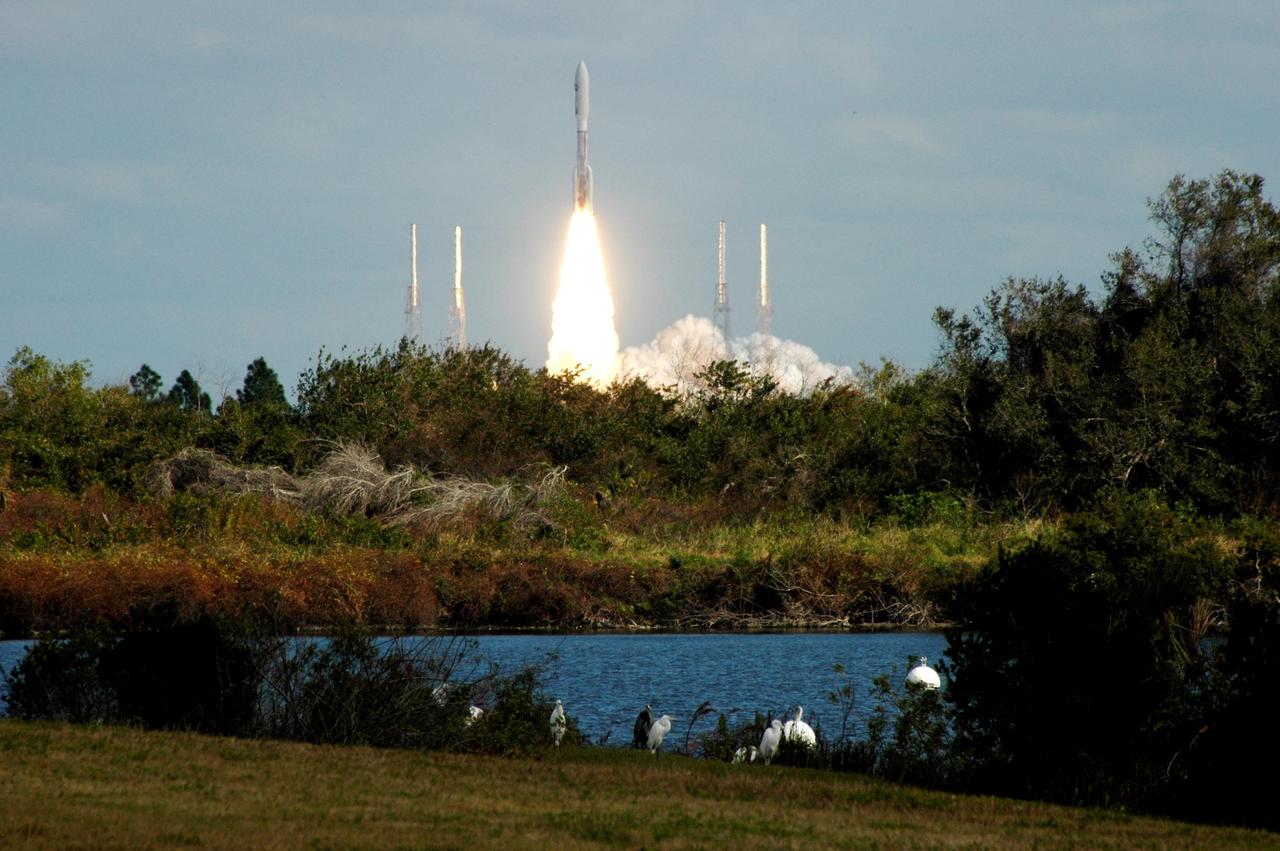 KENNEDY SPACE CENTER, FLA. — Great white egrets and a great blue heron in the foreground seem to stand watch as NASA’s New Horizons spacecraft leaps off the pad on time at 2 p.m. EST aboard an Atlas V rocket from Complex 41 on Cape Canaveral Air Force Station in Florida. This was the third launch attempt in as many days after scrubs due to weather concerns. The compact, 1,050-pound piano-sized probe will get a boost from a kick-stage solid propellant motor for its journey to Pluto. New Horizons will be the fastest spacecraft ever launched, reaching lunar orbit distance in just nine hours and passing Jupiter 13 months later. The New Horizons science payload, developed under direction of Southwest Research Institute, includes imaging infrared and ultraviolet spectrometers, a multi-color camera, a long-range telescopic camera, two particle spectrometers, a space-dust detector and a radio science experiment. The dust counter was designed and built by students at the University of Colorado, Boulder. The launch at this time allows New Horizons to fly past Jupiter in early 2007 and use the planet’s gravity as a slingshot toward Pluto. The Jupiter flyby trims the trip to Pluto by as many as five years and provides opportunities to test the spacecraft’s instruments and flyby capabilities on the Jupiter system. New Horizons could reach the Pluto system as early as mid-2015, conducting a five-month-long study possible only from the close-up vantage of a spacecraft. Photo credit: NASA/Ken Thornsley