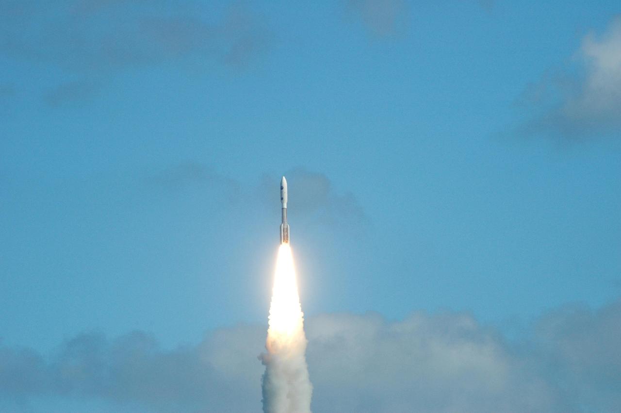 KENNEDY SPACE CENTER, FLA. — Clouds part as NASA’s New Horizons spacecraft roars into the blue sky after an on-time liftoff at 2 p.m. EST aboard an Atlas V rocket from Complex 41 on Cape Canaveral Air Force Station in Florida. This was the third launch attempt in as many days after scrubs due to weather concerns. The compact, 1,050-pound piano-sized probe will get a boost from a kick-stage solid propellant motor for its journey to Pluto. New Horizons will be the fastest spacecraft ever launched, reaching lunar orbit distance in just nine hours and passing Jupiter 13 months later. The New Horizons science payload, developed under direction of Southwest Research Institute, includes imaging infrared and ultraviolet spectrometers, a multi-color camera, a long-range telescopic camera, two particle spectrometers, a space-dust detector and a radio science experiment. The dust counter was designed and built by students at the University of Colorado, Boulder. The launch at this time allows New Horizons to fly past Jupiter in early 2007 and use the planet’s gravity as a slingshot toward Pluto. The Jupiter flyby trims the trip to Pluto by as many as five years and provides opportunities to test the spacecraft’s instruments and flyby capabilities on the Jupiter system. New Horizons could reach the Pluto system as early as mid-2015, conducting a five-month-long study possible only from the close-up vantage of a spacecraft. Photo credit: NASA/Ken Thornsley