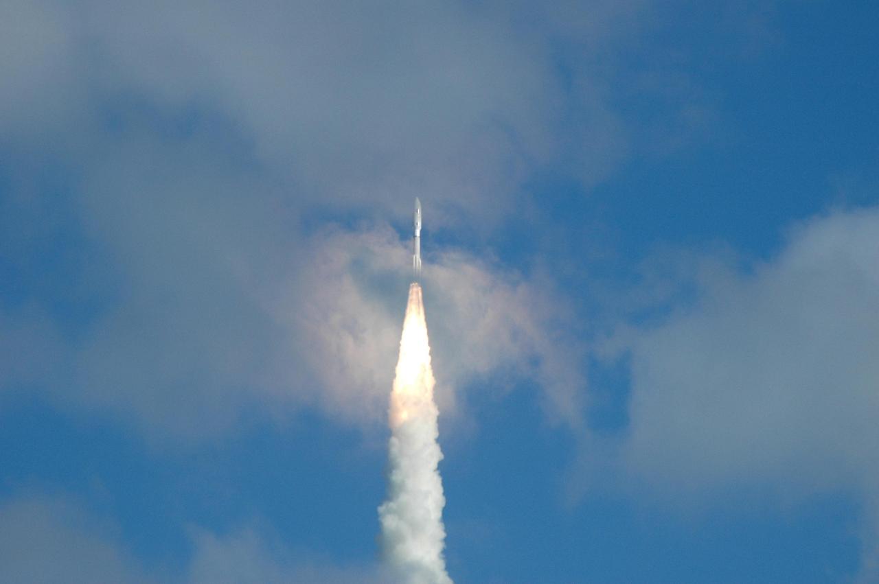 KENNEDY SPACE CENTER, FLA. — NASA’s New Horizons spacecraft pierces a cloud as it roars toward space after an on-time liftoff at 2 p.m. EST aboard an Atlas V rocket from Complex 41 on Cape Canaveral Air Force Station in Florida. This was the third launch attempt in as many days after scrubs due to weather concerns. The compact, 1,050-pound piano-sized probe will get a boost from a kick-stage solid propellant motor for its journey to Pluto. New Horizons will be the fastest spacecraft ever launched, reaching lunar orbit distance in just nine hours and passing Jupiter 13 months later. The New Horizons science payload, developed under direction of Southwest Research Institute, includes imaging infrared and ultraviolet spectrometers, a multi-color camera, a long-range telescopic camera, two particle spectrometers, a space-dust detector and a radio science experiment. The dust counter was designed and built by students at the University of Colorado, Boulder. The launch at this time allows New Horizons to fly past Jupiter in early 2007 and use the planet’s gravity as a slingshot toward Pluto. The Jupiter flyby trims the trip to Pluto by as many as five years and provides opportunities to test the spacecraft’s instruments and flyby capabilities on the Jupiter system. New Horizons could reach the Pluto system as early as mid-2015, conducting a five-month-long study possible only from the close-up vantage of a spacecraft. Photo credit: NASA/Ken Thornsley
