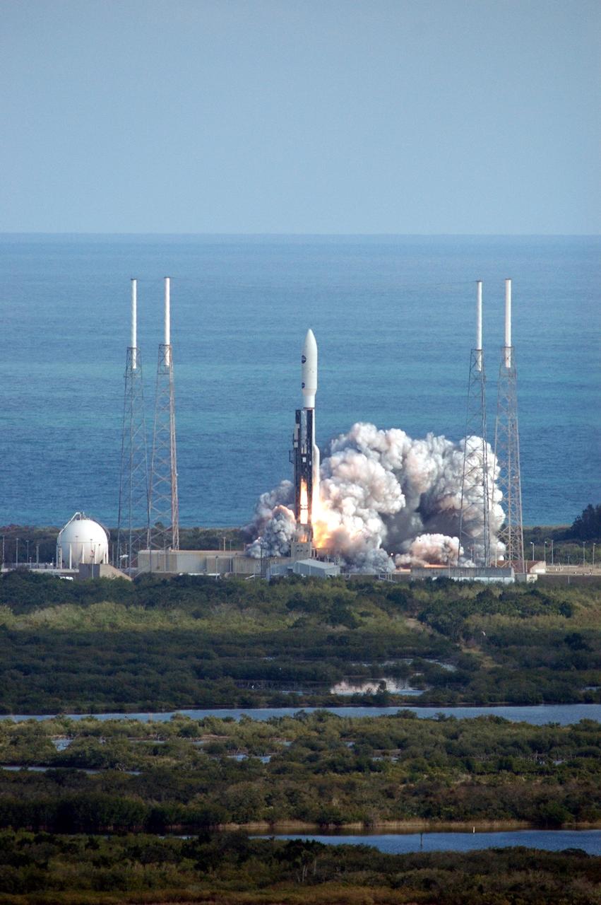 KENNEDY SPACE CENTER, FLA. — Viewed from the top of the Vehicle Assembly Building at Kennedy Space Center, the blue Atlantic Ocean frames NASA’s New Horizons spacecraft as it launches from Complex 41 on Cape Canaveral Air Force Station in Florida. Liftoff was on time at 2 p.m. EST. This was the third launch attempt in as many days after scrubs due to weather concerns. The compact, 1,050-pound piano-sized probe will get a boost from a kick-stage solid propellant motor for its journey to Pluto. New Horizons will be the fastest spacecraft ever launched, reaching lunar orbit distance in just nine hours and passing Jupiter 13 months later. The New Horizons science payload, developed under direction of Southwest Research Institute, includes imaging infrared and ultraviolet spectrometers, a multi-color camera, a long-range telescopic camera, two particle spectrometers, a space-dust detector and a radio science experiment. The dust counter was designed and built by students at the University of Colorado, Boulder. The launch at this time allows New Horizons to fly past Jupiter in early 2007 and use the planet’s gravity as a slingshot toward Pluto. The Jupiter flyby trims the trip to Pluto by as many as five years and provides opportunities to test the spacecraft’s instruments and flyby capabilities on the Jupiter system. New Horizons could reach the Pluto system as early as mid-2015, conducting a five-month-long study possible only from the close-up vantage of a spacecraft. Photo credit: NASA/Kim Shiflett