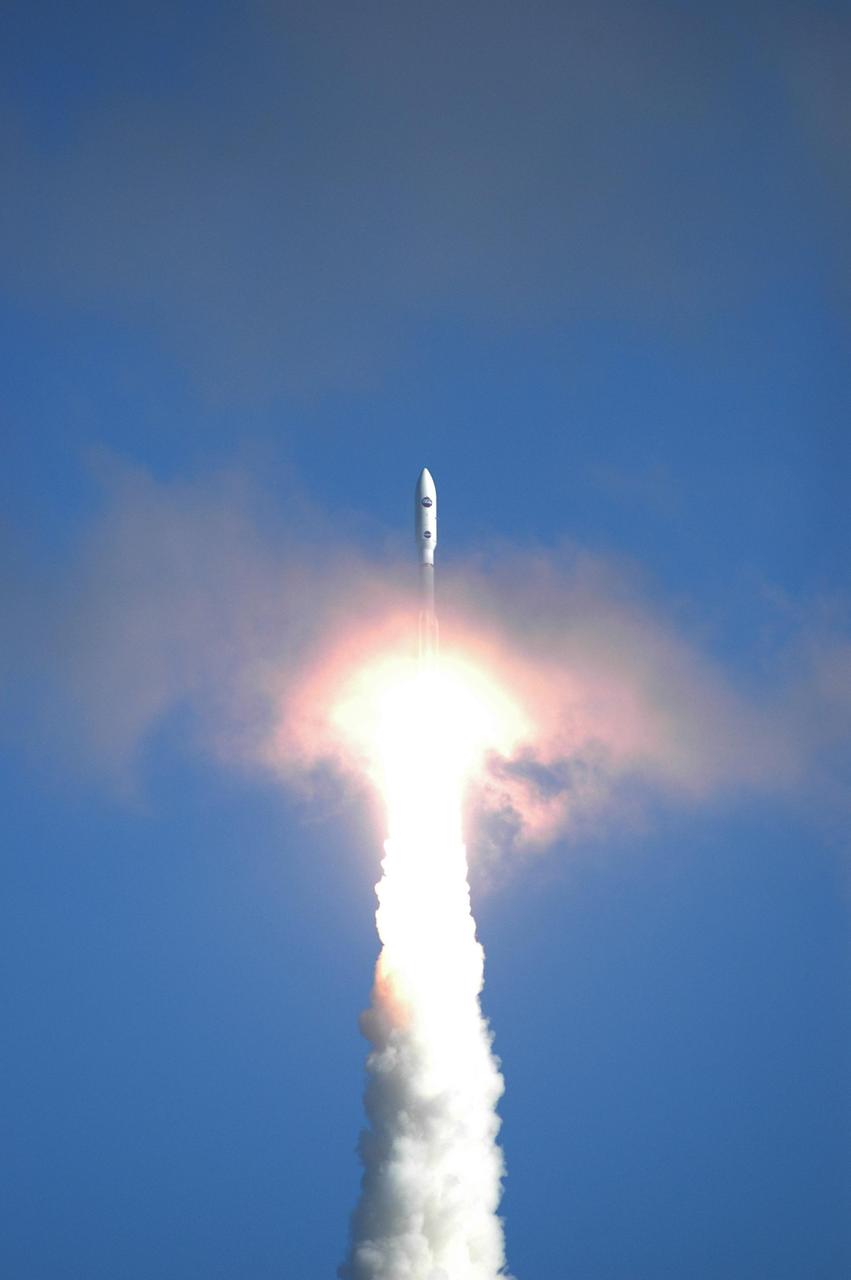 KENNEDY SPACE CENTER, FLA. — NASA’s New Horizons spacecraft emerges from a cloud painted pink by the Atlas V rocket roaring through it after launch from Complex 41 on Cape Canaveral Air Force Station in Florida. Liftoff was on time at 2 p.m. EST. This was the third launch attempt in as many days after scrubs due to weather concerns. The compact, 1,050-pound piano-sized probe will get a boost from a kick-stage solid propellant motor for its journey to Pluto. New Horizons will be the fastest spacecraft ever launched, reaching lunar orbit distance in just nine hours and passing Jupiter 13 months later. The New Horizons science payload, developed under direction of Southwest Research Institute, includes imaging infrared and ultraviolet spectrometers, a multi-color camera, a long-range telescopic camera, two particle spectrometers, a space-dust detector and a radio science experiment. The dust counter was designed and built by students at the University of Colorado, Boulder. The launch at this time allows New Horizons to fly past Jupiter in early 2007 and use the planet’s gravity as a slingshot toward Pluto. The Jupiter flyby trims the trip to Pluto by as many as five years and provides opportunities to test the spacecraft’s instruments and flyby capabilities on the Jupiter system. New Horizons could reach the Pluto system as early as mid-2015, conducting a five-month-long study possible only from the close-up vantage of a spacecraft. Photo credit: NASA/Kim Shiflett