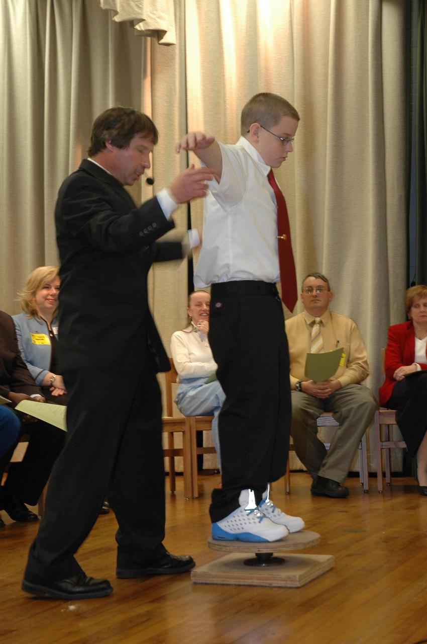 KENNEDY SPACE CENTER, FLA.  — During kickoff of the NASA Explorer School program at Warrington Middle School in Pensacola, Fla., NASA aerospace specialist Les Gold involves a student in a demonstration on stage.  Gold, Center Director Jim Kennedy, astronaut Alan Poindexter and others are visiting the school to share the vision for space exploration with the next generation.   He is talking with students about our destiny as explorers, NASA’s stepping stone approach to exploring Earth, the moon, Mars and beyond, how space impacts our lives, and how people and machines rely on each other in space.  NES establishes a three-year partnership annually between NASA and 50 NASA Explorer School teams, consisting of teachers and education administrators from diverse communities nationwide.  Photo credit: NASA/Cory Huston