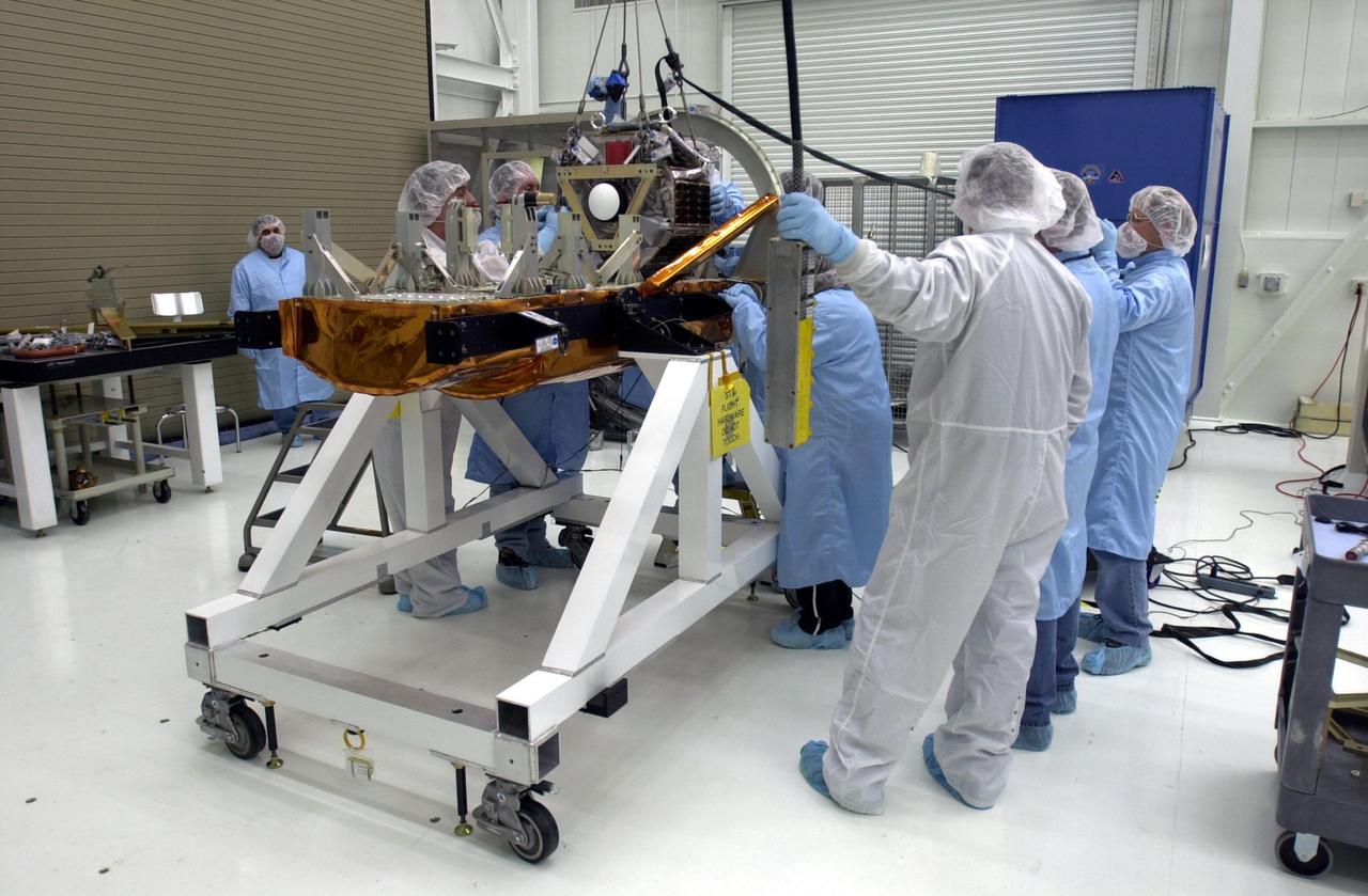 VANDENBERG AIR FORCE BASE, Calif.  —  In the Orbital Sciences Building 836 at Vandenberg Air Force Base in California, workers secure one of three micro-satellites onto a payload support structure.   The three satellites that make up the Space Technology 5 spacecraft, called ST5, will be launched by a Pegasus XL rocket. The satellites  contain miniaturized redundant components and technologies.  Each will validate New Millennium Program selected technologies, such as the Cold Gas Micro-Thruster and X-Band Transponder Communication System.  After deployment from the Pegasus, the micro-satellites will be positioned in a “string of pearls” constellation that demonstrates the ability to position them to perform simultaneous multi-point measurements of the magnetic field using highly sensitive magnetometers.  The data will help scientists understand and map the intensity and direction of the Earth’s magnetic field, its relation to space weather events, and affects on our planet.  With such missions, NASA hopes to improve scientists’ ability to accurately forecast space weather and minimize its harmful effects on space- and ground-based systems.  Launch of ST5 is scheduled for Feb. 28 from Vandenberg Air Force Base.