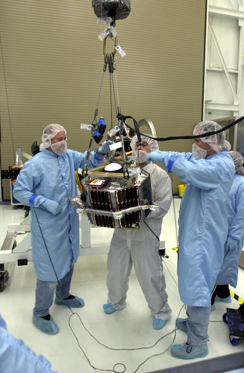 VANDENBERG AIR FORCE BASE, Calif.  —  In the Orbital Sciences Building 836 at Vandenberg Air Force Base in California, workers are maneuvering a second satellite suspended by an overhead crane.  Three micro-satellites are being mounted on a payload support structure.  The three satellites make up the Space Technology 5 spacecraft, called ST5, and will be launched by a Pegasus XL rocket. The satellites contain miniaturized redundant components and technologies.  Each will validate New Millennium Program selected technologies, such as the Cold Gas Micro-Thruster and X-Band Transponder Communication System.  After deployment from the Pegasus, the micro-satellites will be positioned in a “string of pearls” constellation that demonstrates the ability to position them to perform simultaneous multi-point measurements of the magnetic field using highly sensitive magnetometers.  The data will help scientists understand and map the intensity and direction of the Earth’s magnetic field, its relation to space weather events, and affects on our planet.  With such missions, NASA hopes to improve scientists’ ability to accurately forecast space weather and minimize its harmful effects on space- and ground-based systems.  Launch of ST5 is scheduled for Feb. 28 from Vandenberg Air Force Base.