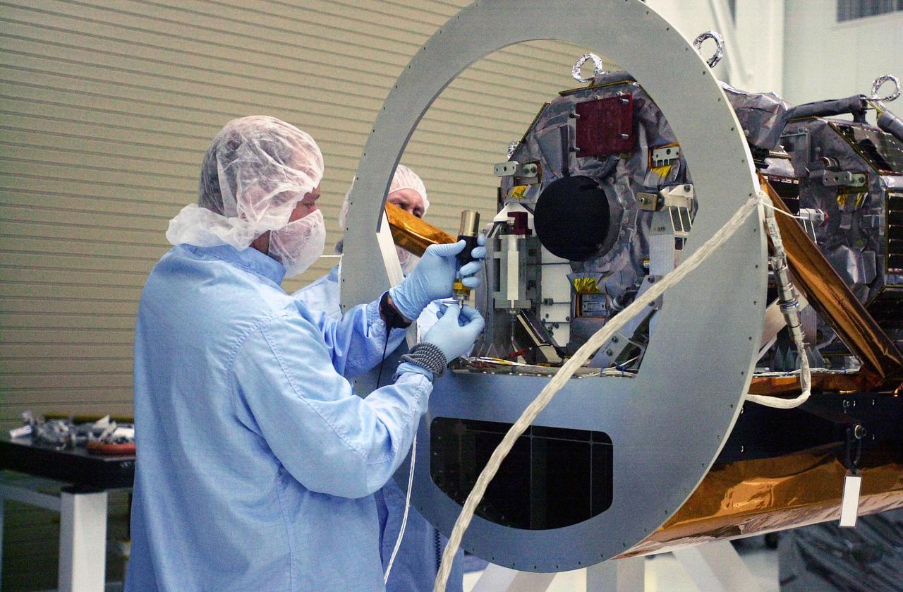 VANDENBERG AIR FORCE BASE, Calif.  —  In the Orbital Sciences Building 836 at Vandenberg Air Force Base in California, technicians complete mating of the three micro-satellites on the payload support structure.  The three satellites make up the Space Technology 5 spacecraft, called ST5, and will be launched by a Pegasus XL rocket. The satellites contain miniaturized redundant components and technologies.  Each will validate New Millennium Program selected technologies, such as the Cold Gas Micro-Thruster and X-Band Transponder Communication System.  After deployment from the Pegasus, the micro-satellites will be positioned in a “string of pearls” constellation that demonstrates the ability to position them to perform simultaneous multi-point measurements of the magnetic field using highly sensitive magnetometers.  The data will help scientists understand and map the intensity and direction of the Earth’s magnetic field, its relation to space weather events, and affects on our planet.  With such missions, NASA hopes to improve scientists’ ability to accurately forecast space weather and minimize its harmful effects on space- and ground-based systems.  Launch of ST5 is scheduled for Feb. 28 from Vandenberg Air Force Base.