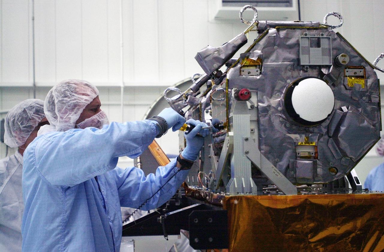 VANDENBERG AIR FORCE BASE, Calif.  —  In the Orbital Sciences Building 836 at Vandenberg Air Force Base in California, technicians complete mating of the three micro-satellites on the payload support structure. The three satellites make up the Space Technology 5 spacecraft, called ST5, and will be launched by a Pegasus XL rocket. The satellites contain miniaturized redundant components and technologies.  Each will validate New Millennium Program selected technologies, such as the Cold Gas Micro-Thruster and X-Band Transponder Communication System.  After deployment from the Pegasus, the micro-satellites will be positioned in a “string of pearls” constellation that demonstrates the ability to position them to perform simultaneous multi-point measurements of the magnetic field using highly sensitive magnetometers.  The data will help scientists understand and map the intensity and direction of the Earth’s magnetic field, its relation to space weather events, and affects on our planet.  With such missions, NASA hopes to improve scientists’ ability to accurately forecast space weather and minimize its harmful effects on space- and ground-based systems.  Launch of ST5 is scheduled for Feb. 28 from Vandenberg Air Force Base.