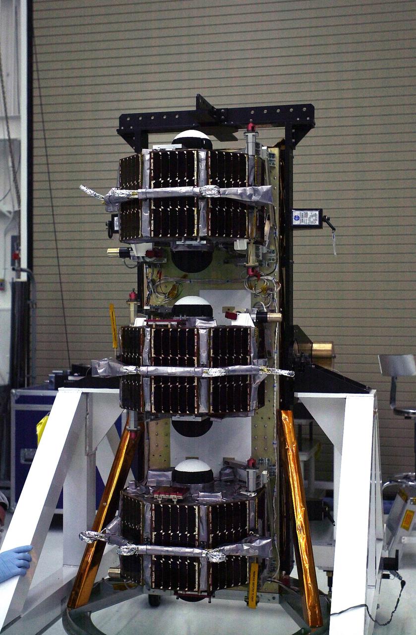 VANDENBERG AIR FORCE BASE, Calif.  —  In In the Orbital Sciences Building 836 at Vandenberg Air Force Base in California, the payload support structure with the three micro-satellites comprising the Space Technology 5 (ST5) spacecraft has been raised to vertical to be weighed.  ST5 will be launched by a Pegasus XL rocket. The satellites contain miniaturized redundant components and technologies.  Each will validate New Millennium Program selected technologies, such as the Cold Gas Micro-Thruster and X-Band Transponder Communication System.  After deployment from the Pegasus, the micro-satellites will be positioned in a “string of pearls” constellation that demonstrates the ability to position them to perform simultaneous multi-point measurements of the magnetic field using highly sensitive magnetometers.  The data will help scientists understand and map the intensity and direction of the Earth’s magnetic field, its relation to space weather events, and affects on our planet.  With such missions, NASA hopes to improve scientists’ ability to accurately forecast space weather and minimize its harmful effects on space- and ground-based systems.  Launch of ST5 is scheduled for Feb. 28 from Vandenberg Air Force Base.