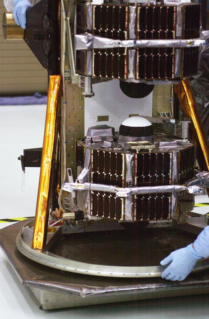 VANDENBERG AIR FORCE BASE, Calif.  —  In the Orbital Sciences Building 836 at Vandenberg Air Force Base in California, workers keep close watch as the payload support structure with the three micro-satellites comprising the Space Technology 5 (ST5) spacecraft is lifted and weighed.  ST5 will be launched by a Pegasus XL rocket. The satellites contain miniaturized redundant components and technologies.  Each will validate New Millennium Program selected technologies, such as the Cold Gas Micro-Thruster and X-Band Transponder Communication System.  After deployment from the Pegasus, the micro-satellites will be positioned in a “string of pearls” constellation that demonstrates the ability to position them to perform simultaneous multi-point measurements of the magnetic field using highly sensitive magnetometers.  The data will help scientists understand and map the intensity and direction of the Earth’s magnetic field, its relation to space weather events, and affects on our planet.  With such missions, NASA hopes to improve scientists’ ability to accurately forecast space weather and minimize its harmful effects on space- and ground-based systems.  Launch of ST5 is scheduled for Feb. 28 from Vandenberg Air Force Base.
