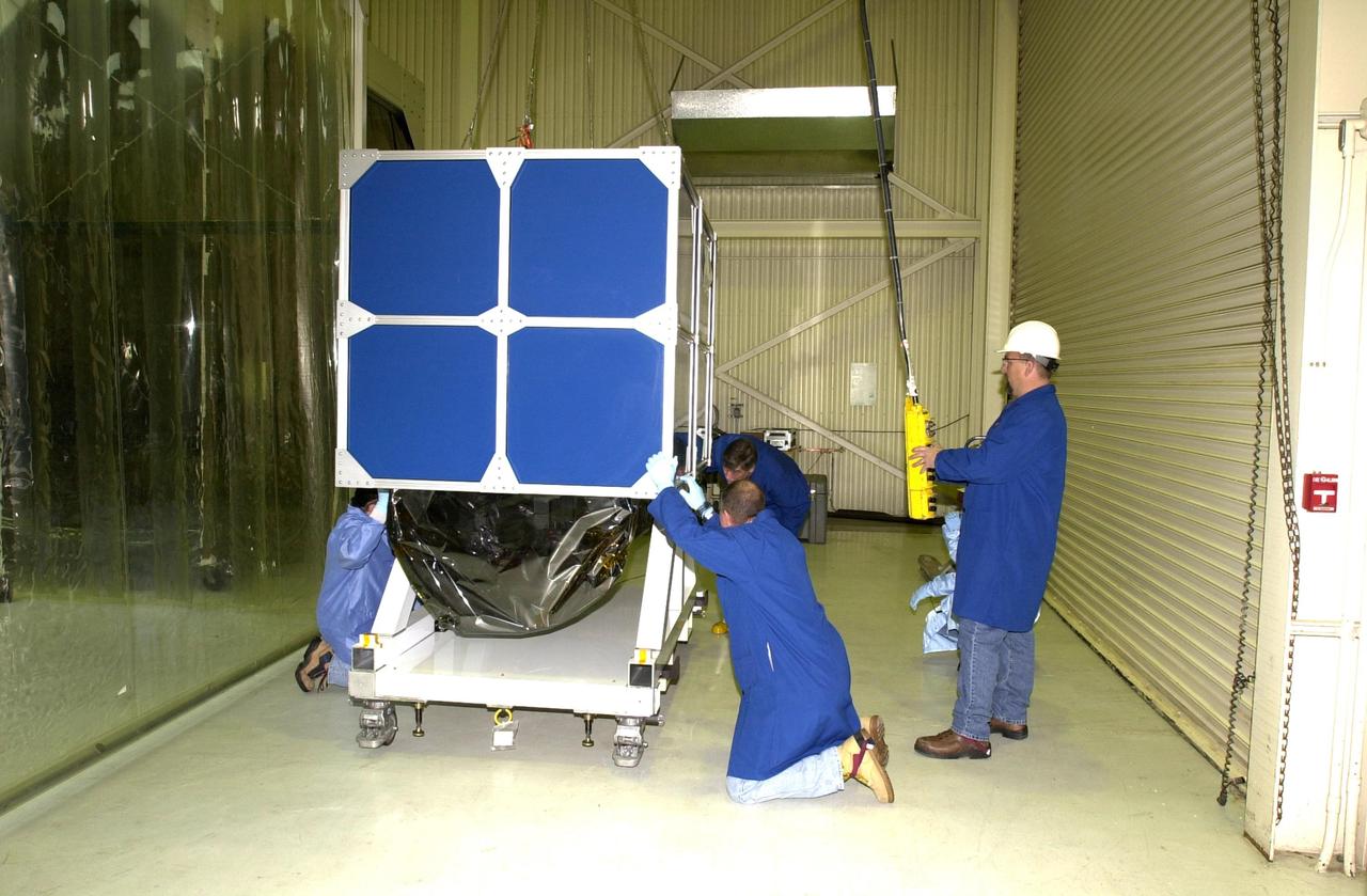 VANDENBERG AIR FORCE BASE, Calif.  —  Inside Orbital Sciences’ Building 1555 at Vandenberg Air Force Base in California, workers assure the shipping container surrounding the Space Technology 5 (ST5) spacecraft is lifted safely. ST5 will be launched by a Pegasus XL rocket. The satellites contain miniaturized redundant components and technologies.  Each will validate New Millennium Program selected technologies, such as the Cold Gas Micro-Thruster and X-Band Transponder Communication System.  After deployment from the Pegasus, the micro-satellites will be positioned in a “string of pearls” constellation that demonstrates the ability to position them to perform simultaneous multi-point measurements of the magnetic field using highly sensitive magnetometers.  The data will help scientists understand and map the intensity and direction of the Earth’s magnetic field, its relation to space weather events, and affects on our planet.  With such missions, NASA hopes to improve scientists’ ability to accurately forecast space weather and minimize its harmful effects on space- and ground-based systems.  Launch of ST5 is scheduled for Feb. 28 from Vandenberg Air Force Base.