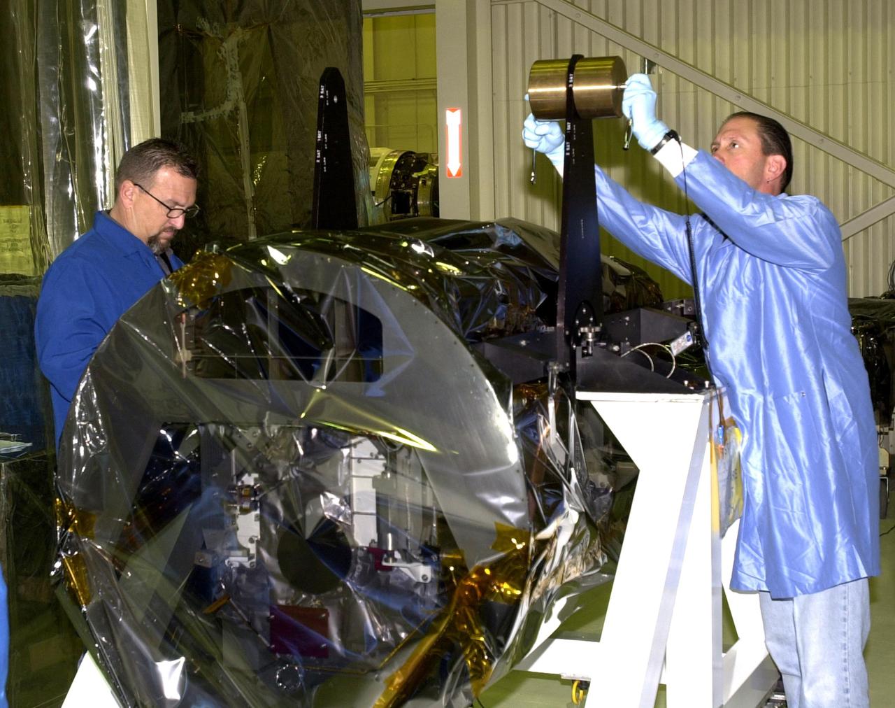 VANDENBERG AIR FORCE BASE, Calif.  —  Inside Orbital Sciences’ Building 1555 at Vandenberg Air Force Base in California, the wrapped Space Technology 5 (ST5) spacecraft is being prepared for mating to the Pegasus XL launch vehicle.  The satellites contain miniaturized redundant components and technologies.  Each will validate New Millennium Program selected technologies, such as the Cold Gas Micro-Thruster and X-Band Transponder Communication System.  After deployment from the Pegasus, the micro-satellites will be positioned in a “string of pearls” constellation that demonstrates the ability to position them to perform simultaneous multi-point measurements of the magnetic field using highly sensitive magnetometers.  The data will help scientists understand and map the intensity and direction of the Earth’s magnetic field, its relation to space weather events, and affects on our planet.  With such missions, NASA hopes to improve scientists’ ability to accurately forecast space weather and minimize its harmful effects on space- and ground-based systems.  Launch of ST5 is scheduled for Feb. 28 from Vandenberg Air Force Base.