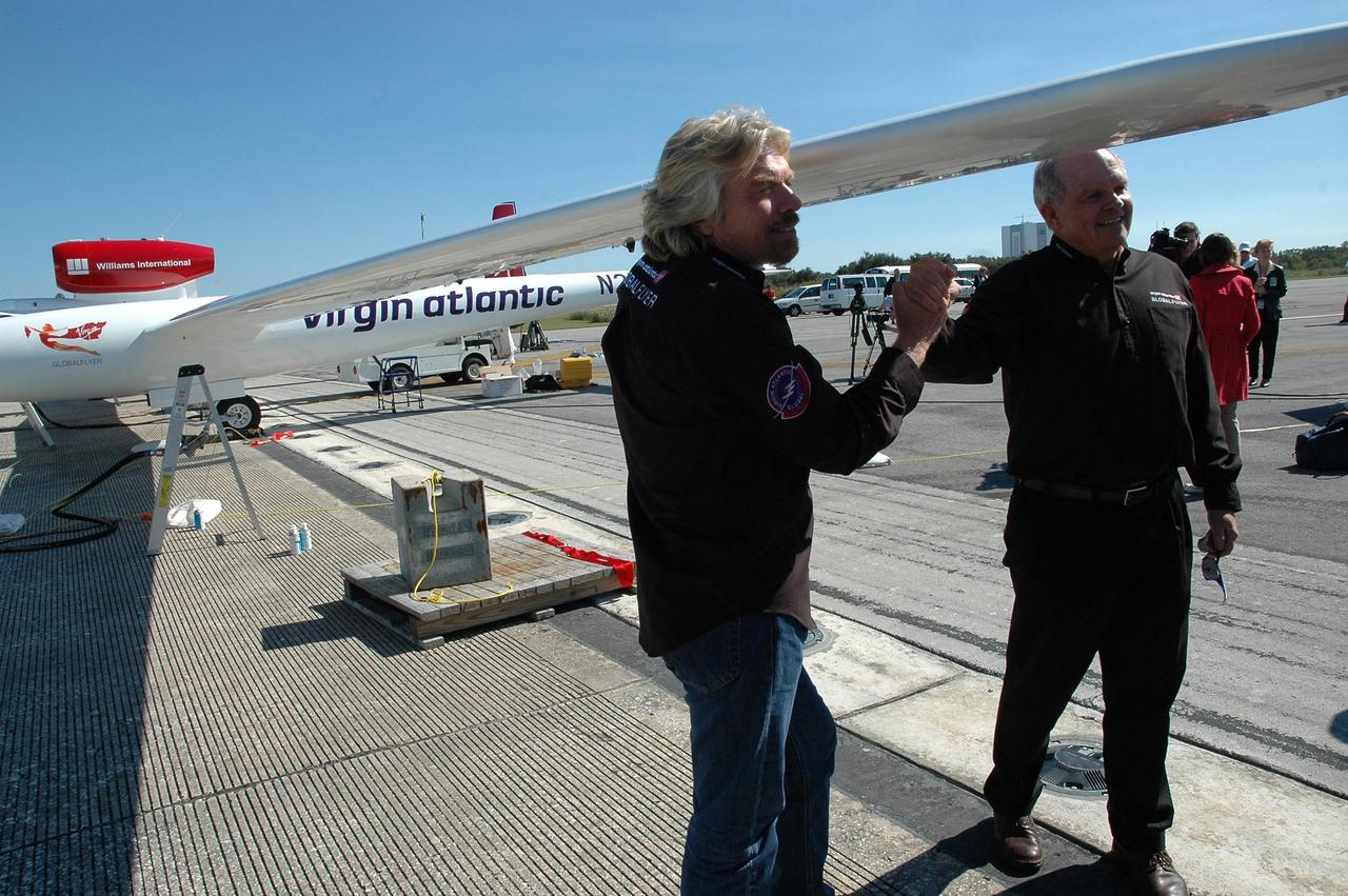 KENNEDY SPACE CENTER, FLA. -  On NASA Kennedy Space Center’s Shuttle Landing Facility, Sir Richard Branson (left), chairman and founder of Virgin Atlantic, talks with Steve Fossett.  They are standing next to the Virgin Atlantic GlobalFlyer aircraft, which Fossett will pilot on a record-breaking attempt by flying solo, non-stop without refueling, to surpass the current record for the longest flight of any aircraft.  Fossett is expected to take off from the Shuttle Landing Facility early Tuesday morning.  Photo credit: NASA/Jack Pfaller