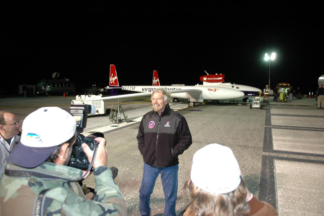 KENNEDY SPACE CENTER, FLA. -   During fueling of the Virgin Atlantic GlobalFlyer before dawn on NASA Kennedy Space Center’s Shuttle Landing Facility (SLF), Sir Richard Branson talks to the media.  Branson is chairman and founder of Virgin Atlantic. The GlobalFlyer is in the background.    Steve Fossett will pilot the GlobalFlyer on a record-breaking attempt by flying solo, non-stop without refueling, to surpass the current record for the longest flight of any aircraft.  Fossett is expected to take off from the KSC SLF.  Later, takeoff of the GlobalFlyer was postponed due to a fuel leak that appeared during the last moments of loading. The next planned takeoff attempt is 7 a.m. Feb. 8 from the SLF.   Photo credit: NASA/Kim Shiflett