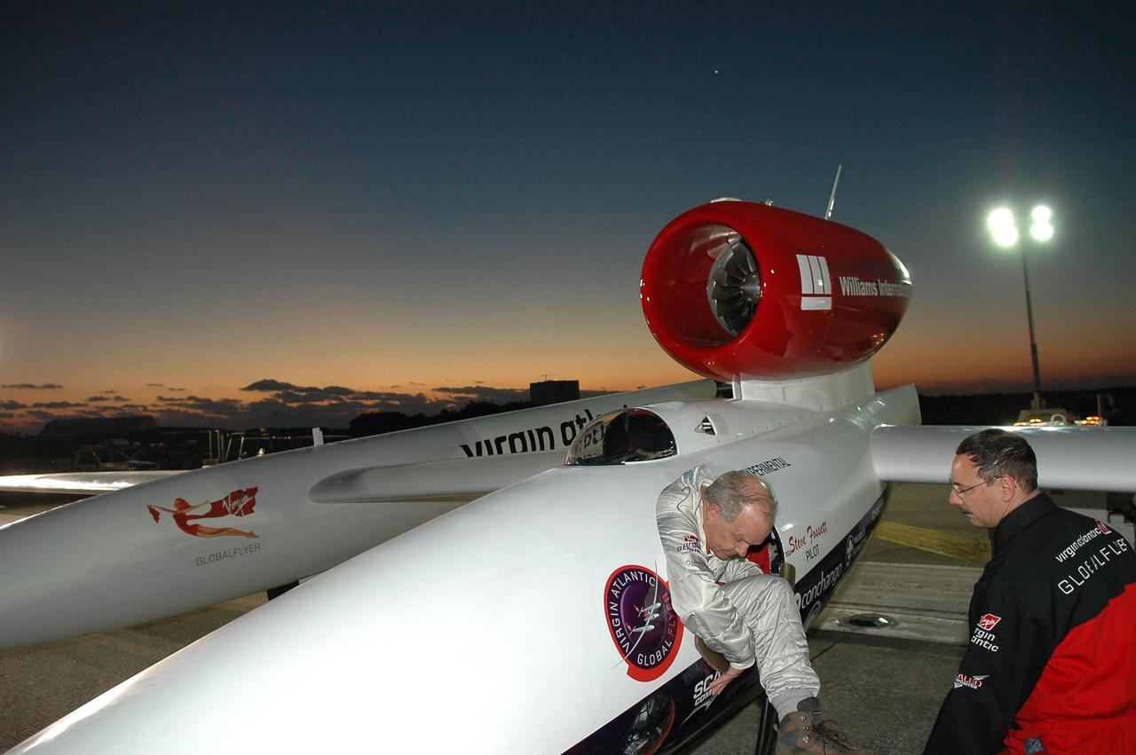 KENNEDY SPACE CENTER, FLA. -   Just at dawn, Steve Fossett (left) climbs into the Virgin Atlantic GlobalFlyer parked on NASA Kennedy Space Center’s Shuttle Landing Facility.  Fossett will pilot the GlobalFlyer on a record-breaking attempt by flying solo, non-stop without refueling, to surpass the current record for the longest flight of any aircraft. This is the second attempt in two days after a fuel leak was detected Feb. 7.  The expected time of takeoff is 7 a.m.  Photo credit: NASA/Kim Shiflett