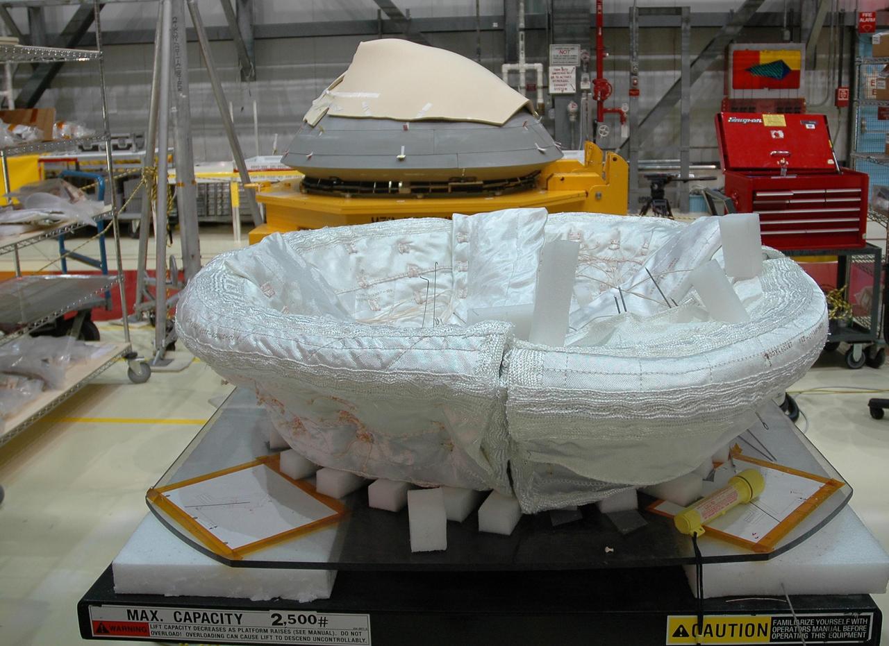KENNEDY SPACE CENTER, FLA. -    The thermal protection system blanket insulation (foreground) has been hand-sewn onto a frame before being installed inside Endeavour's Reinforced Carbon-Carbon nose cap, seen in the background, in the NASA Kennedy Space Center Orbiter Processing Facility bay 2.  Made of a woven ceramic fabric, the special blankets are used to help insulate the vehicle's nose cap and protect it from the extreme temperatures it will face during a mission. Photo credit: NASA/Jack Pfaller.