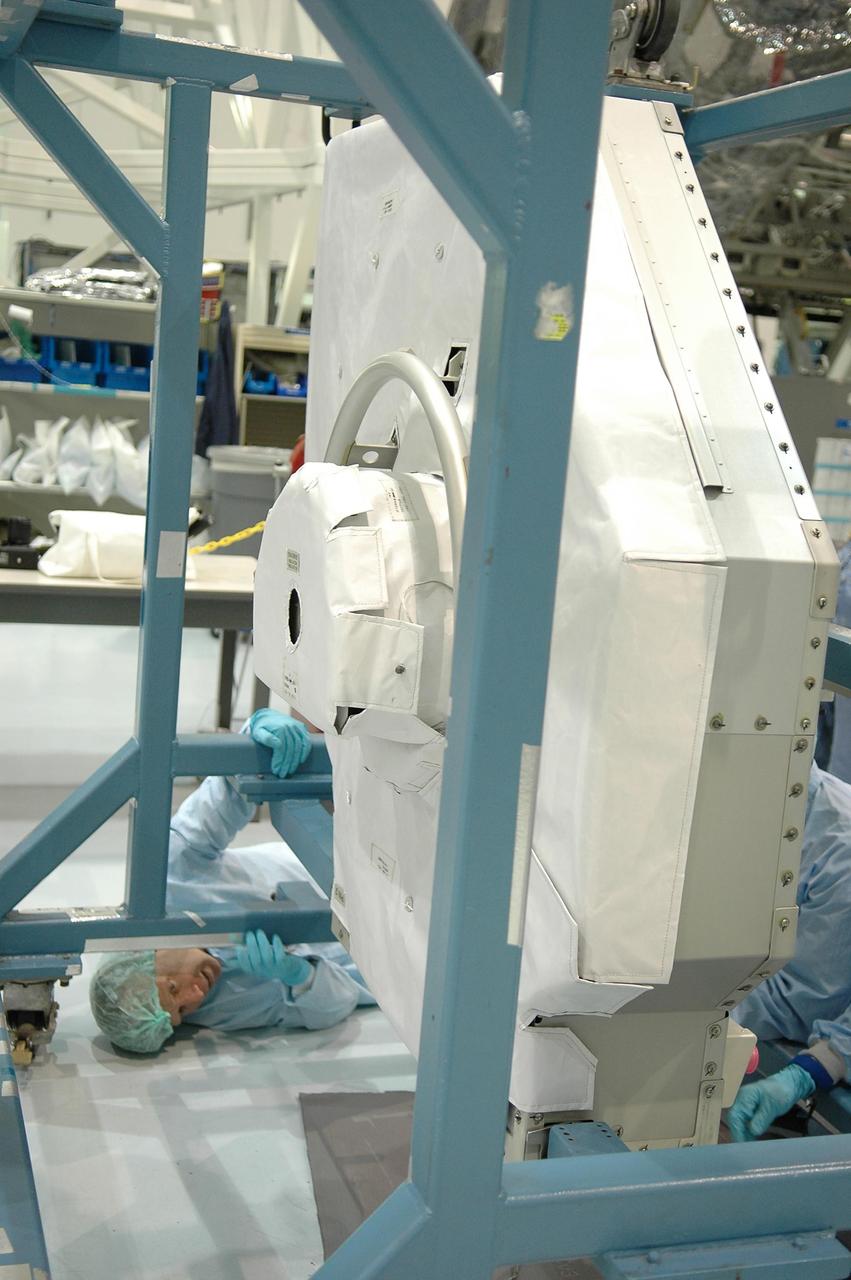 KENNEDY SPACE CENTER, FLA. -   In the Space Station Processing Facility at NASA Kennedy Space Center, STS-121 Mission Specialist Michael Fossum looks underneath the replacement trailing umbilical system reel assembly that will be installed on the International Space Station.  He and other crew members -- Commander Steven Lindsey, Pilot Mark Kelly and Mission Specialists Lisa Nowak, Stephanie Wilson and Piers Sellers -- are at Kennedy to take part in the crew equipment interface test (CEIT).