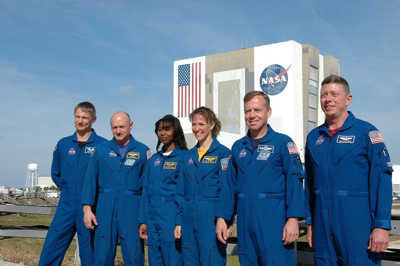 KENNEDY SPACE CENTER, FLA. -   The STS-121 crew stands for a photo in front of the Vehicle Assembly Building after a media conference. From left are Mission Specialist Piers Sellers, Pilot Mark Kelly, Mission Specialists Stephanie Wilson and Lisa Nowak, Commander Steven Lindsey and Mission Specialist Michael Fossum.  The remaining member of the crew, not pictured, is Mission Specialist Thomas Reiter.  The crew is at NASA Kennedy Space Center for the crew equipment interface test, which provides hands-on experiences with equipment used on-orbit.  The launch of STS-121, the second return-to-flight mission, is scheduled for May.   Photo credit: NASA/Kim Shiflett