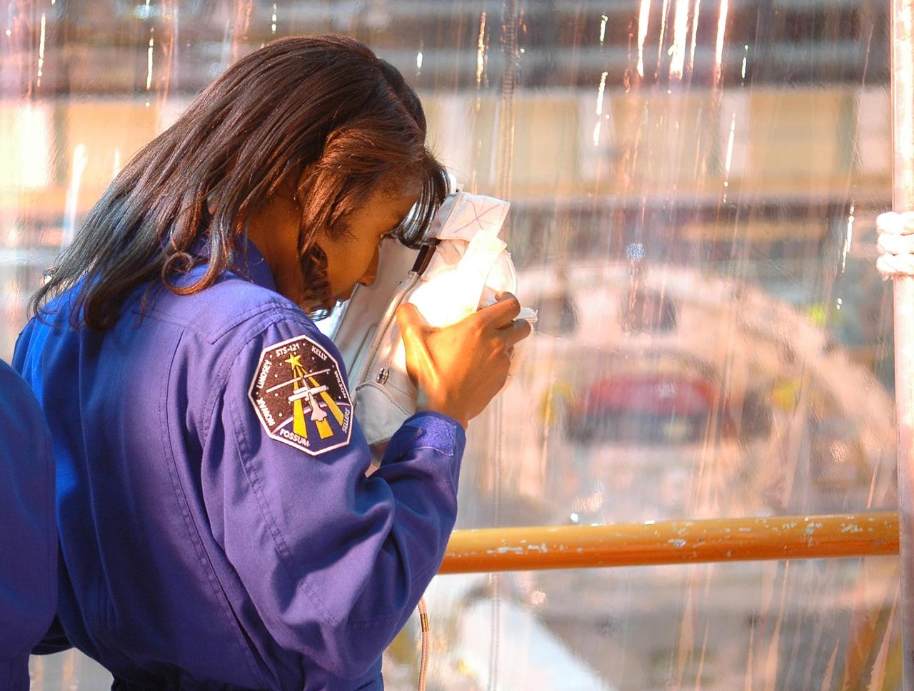 KENNEDY SPACE CENTER, FLA. - Inside the Orbiter Processing Facility bay 3 at NASA's Kennedy Space Center, STS-121 Mission Specialist Lisa Nowak photographs Discovery, the launch vehicle for the mission, during a training session.  She and other crew members -- Commander Steven Lindsey, Pilot Mark Kelly and Mission Specialists Stephanie Wilson, Michael Fossum and Piers Sellers -- are at Kennedy for a crew equipment interface test, which provides hands-on experience with equipment they will use on orbit.  Launch of STS-121, the second return-to-flight mission, is scheduled for no earlier than May.  Photo credit: NASA/Kim Shiflett
