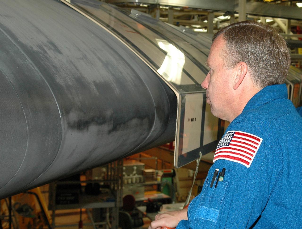 KENNEDY SPACE CENTER, FLA. - Inside the Orbiter Processing Facility bay 3 at NASA's Kennedy Space Center, STS-121 Commander Steven Lindsey gets a close look at the wing leading edge of Discovery, the launch vehicle for the mission. He and other crew members -- Pilot Mark Kelly and Mission Specialists Lisa Nowak, Stephanie Wilson, Michael Fossum and Piers Sellers -- are at Kennedy for a crew equipment interface test, which provides hands-on experience with equipment they will use on orbit.  Launch of STS-121, the second return-to-flight mission, is scheduled for no earlier than May.  Photo credit: NASA/Kim Shiflett