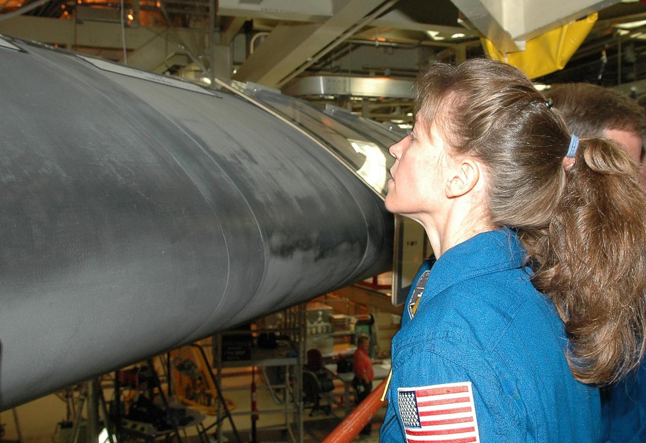 KENNEDY SPACE CENTER, FLA. - Inside the Orbiter Processing Facility bay 3 at NASA's Kennedy Space Center, STS-121 Mission Specialist Lisa Nowak gets a close look at the wing leading edge of Discovery, the launch vehicle for the mission.  She and other crew members -- Commander Steven Lindsey, Pilot Mark Kelly and Mission Specialists Stephanie Wilson, Michael Fossum and Piers Sellers -- are at Kennedy for a crew equipment interface test, which provides hands-on experience with equipment they will use on orbit.  Launch of STS-121, the second return-to-flight mission, is scheduled for no earlier than May.  Photo credit: NASA/Kim Shiflett