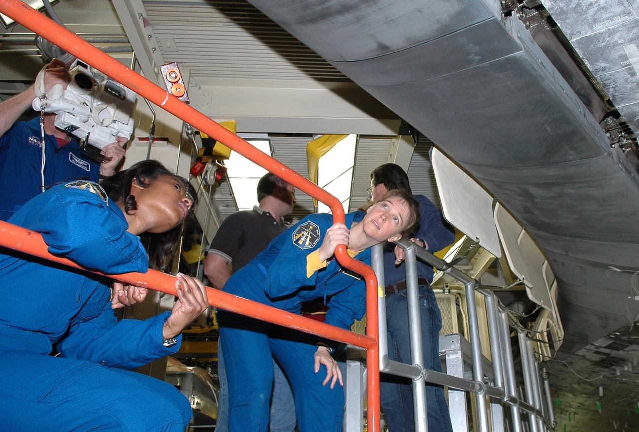 KENNEDY SPACE CENTER, FLA. - Inside the Orbiter Processing Facility bay 3 at NASA's Kennedy Space Center, STS-121 Mission Specialist Lisa Nowak and Commander Steven Lindsey take a close look at the wing leading edge of Discovery, the launch vehicle for the mission.  They and other crew members -- Pilot Mark Kelly and Mission Specialists Stephanie Wilson, Michael Fossum and Piers Sellers -- are at Kennedy for a crew equipment interface test, which provides hands-on experience with equipment they will use on orbit. Launch of STS-121, the second return-to-flight mission, is scheduled for no earlier than May.  Photo credit: NASA/Kim Shiflett