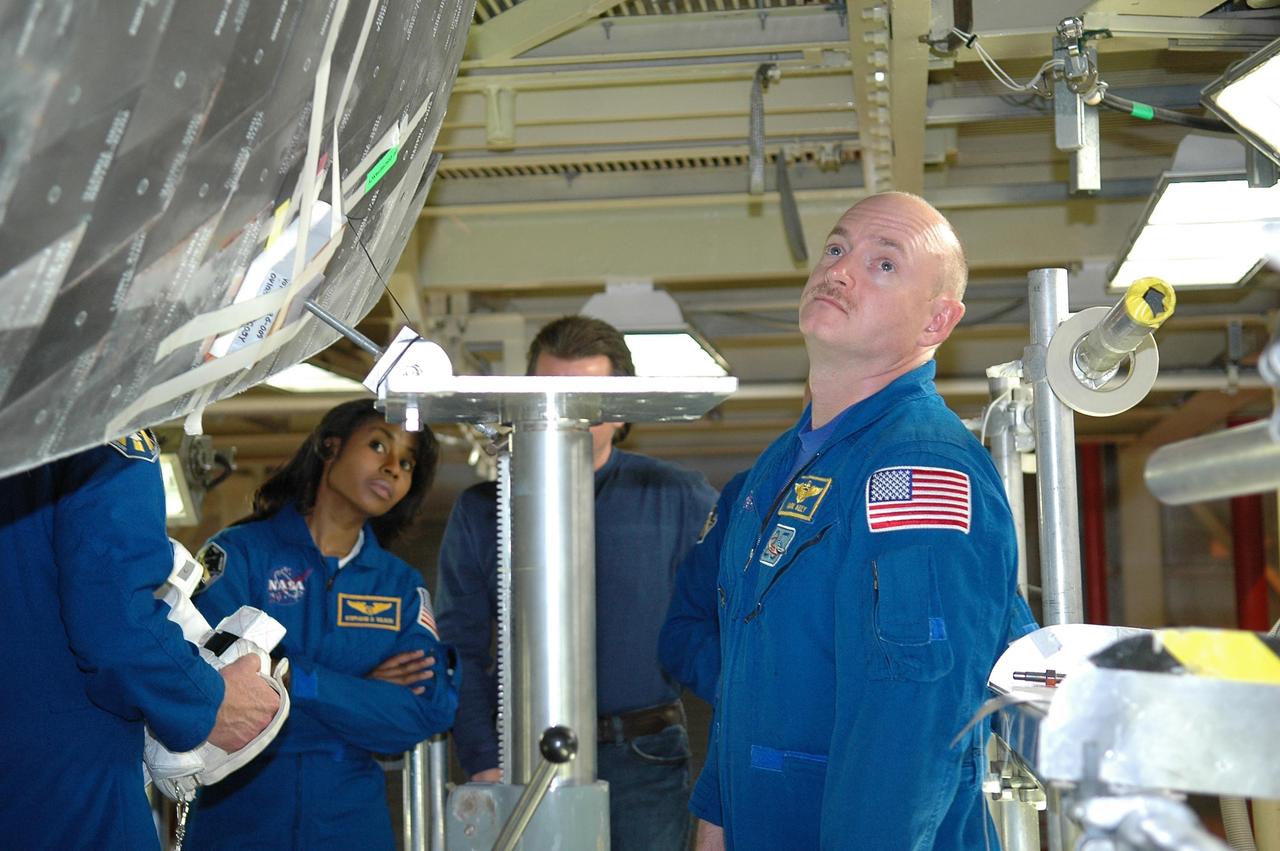 KENNEDY SPACE CENTER, FLA. -  Inside the Orbiter Processing Facility bay 3 at NASA's Kennedy Space Center, members of the STS-121 crew take a close look at Discovery, the launch vehicle for the mission.  Seen are Mission Specialist Stephanie Wilson and Pilot Mark Kelly.  The crew is at Kennedy for the crew equipment interface test, which provides hands-on experience with equipment they will use on orbit.  Launch of STS-121, the second return-to-flight mission, is scheduled for no earlier than May.  Photo credit: NASA/Kim Shiflett