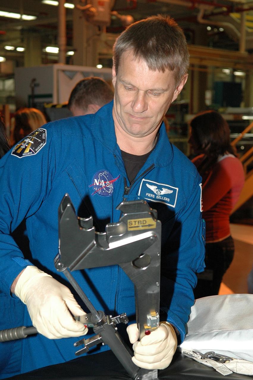 KENNEDY SPACE CENTER, FLA. - In NASA Kennedy Space Center's Orbiter Processing Facility bay 3, STS-121 Mission Specialist Piers Sellers practices using a piece of equipment that will be on the mission.  The crew is at Kennedy to take part in the crew equipment interface test, which provides hands-on experience with equipment to be used on-orbit. Launch of Space Shuttle Discovery on mission STS-121, the second return-to-flight mission, is scheduled no earlier than May.