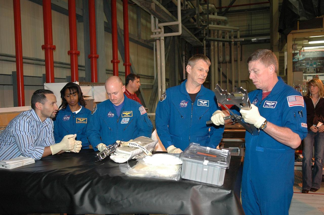 KENNEDY SPACE CENTER, FLA. - In NASA Kennedy Space Center's Orbiter Processing Facility bay 3, members of the STS-121 crew practice working with equipment for the mission. Starting from left are Tomas Gonzalez-Torres, with NASA's Johnson Space Center; Mission Specialist Stephanie Wilson, Pilot Mark Kelly, and Mission Specialists Piers Sellers and Michael Fossum.  The crew is at Kennedy to take part in the crew equipment interface test, which provides hands-on experience with equipment to be used on-orbit. Launch of Space Shuttle Discovery on mission STS-121, the second return-to-flight mission, is scheduled no earlier than May.