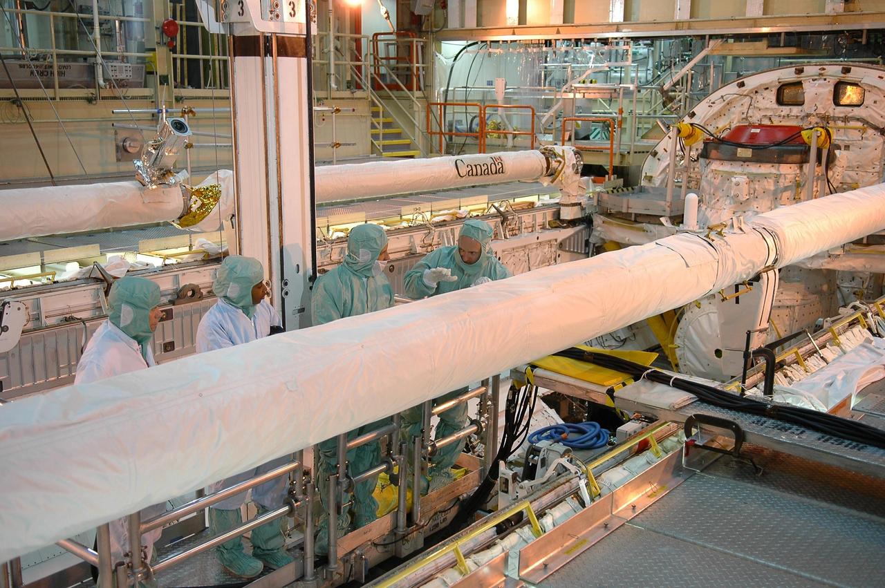 KENNEDY SPACE CENTER, FLA. - In NASA Kennedy Space Center's Orbiter Processing Facility bay 3, STS-121 Pilot Mark Kelly and Mission Specialist Stephanie Wilson are joined by two shuttle technicians as they examine the orbiter boom sensor system in Discovery's payload bay.  The crew is at Kennedy to take part in the crew equipment interface test, which provides hands-on experience with equipment to be used on-orbit.  Launch of Space Shuttle Discovery on mission STS-121, the second return-to-flight mission, is scheduled no earlier than May.