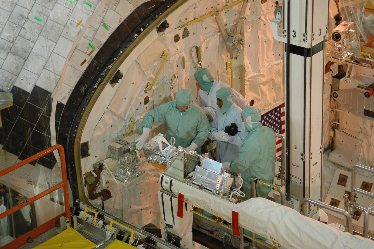 KENNEDY SPACE CENTER, FLA. - In NASA Kennedy Space Center's Orbiter Processing Facility bay 3, STS-121 Pilot Mark Kelly and Mission Specialist Stephanie Wilson are joined by two shuttle technicians as they work with equipment that will be on the mission. The crew is at Kennedy to take part in the crew equipment interface test, which provides hands-on experience with equipment to be used on-orbit.  Launch of Space Shuttle Discovery on mission STS-121, the second return-to-flight mission, is scheduled no earlier than May.