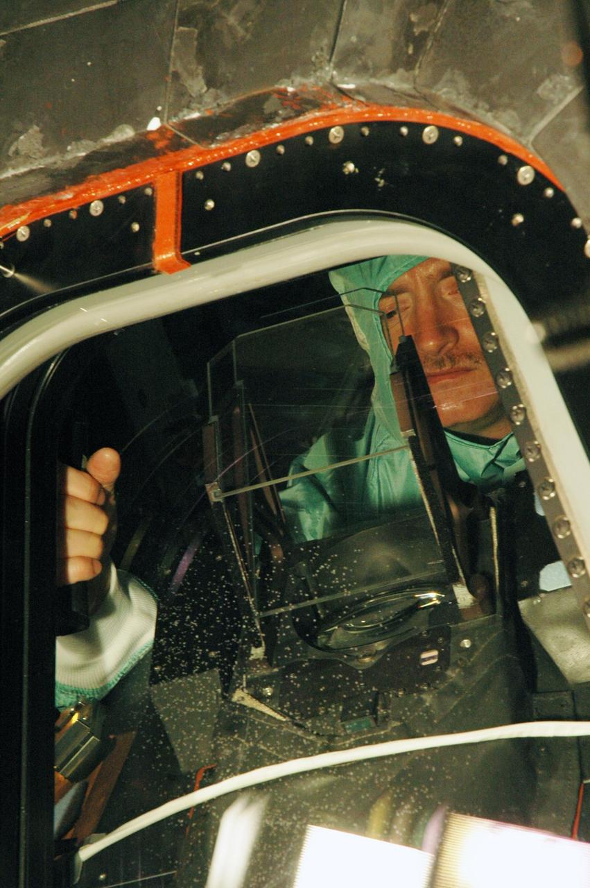 KENNEDY SPACE CENTER, FLA. - In NASA Kennedy Space Center's Orbiter Processing Facility bay 3, STS-121 Pilot Mark Kelly inspects one of the windows that will fly on Space Shuttle Discovery during the mission. The crew is at Kennedy to take part in the crew equipment interface test, which provides hands-on experience with equipment to be used on-orbit. Launch of Space Shuttle Discovery on mission STS-121, the second return-to-flight mission, is scheduled no earlier than May.