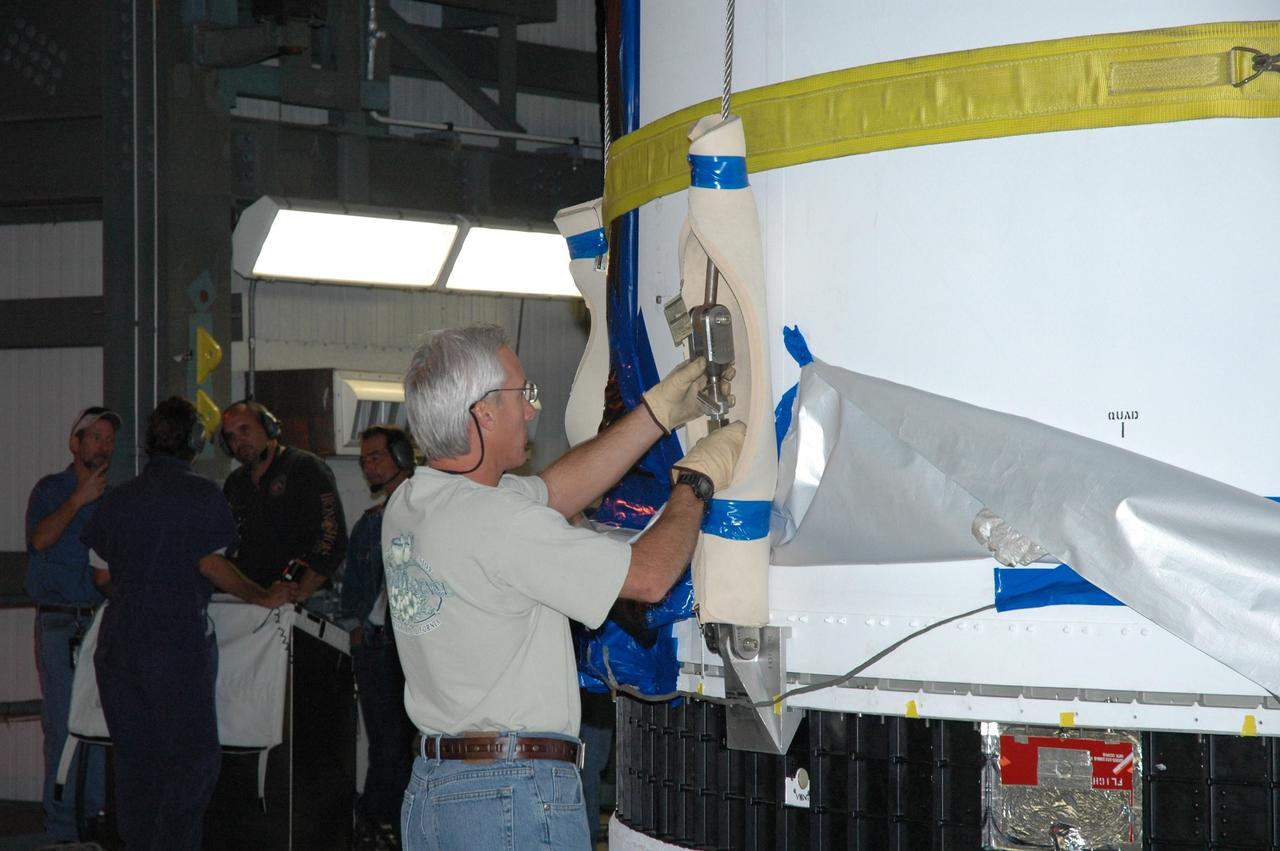 KENNEDY SPACE CENTER, FLA. - On Launch Complex 37 at Cape Canaveral Air Force Station in Florida, a technician demates the GOES-N satellite from its Boeing Delta IV rocket. Launch of the satellite was postponed in August 2005 due to technical issues and postponed to a later date. Due to the extended length of time the spacecraft has been atop the rocket without launching, the weather satellite is being returned to the Astrotech Space Operations payload processing facility for some precautionary retesting and state-of-health checks. GOES-N is the latest in a series of Geostationary Operational Environmental Satellites for NOAA and NASA providing continuous monitoring necessary for intensive data analysis.  Photo credit: NASA/Jim Grossmann