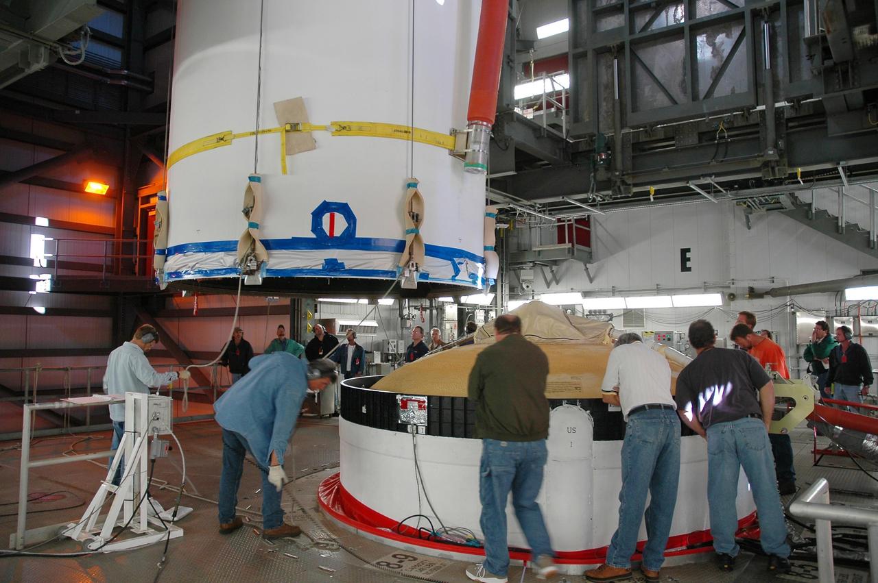 KENNEDY SPACE CENTER, FLA. - On Launch Complex 37 at Cape Canaveral Air Force Station in Florida, technicians demate the GOES-N satellite (upper left) from its Boeing Delta IV rocket (right).  Launch of the satellite was postponed in August 2005 due to technical issues and postponed to a later date. Due to the extended length of time the spacecraft has been atop the rocket without launching, the weather satellite is being returned to the Astrotech Space Operations payload processing facility for some precautionary retesting and state-of-health checks. GOES-N is the latest in a series of Geostationary Operational Environmental Satellites for NOAA and NASA providing continuous monitoring necessary for intensive data analysis.  Photo credit: NASA/Jack Pfaller