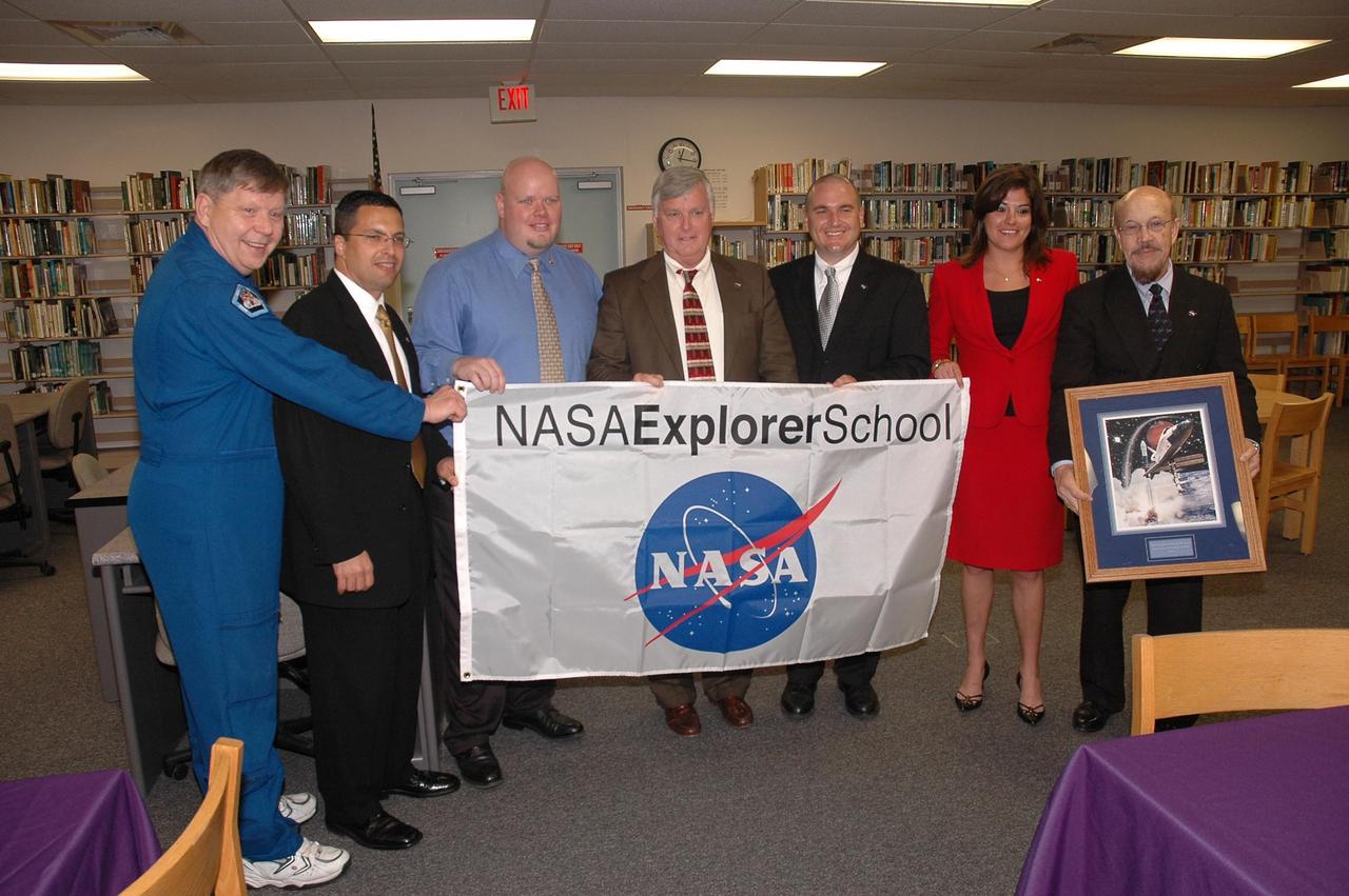 KENNEDY SPACE CENTER, FLA.  - Center Director Jim Kennedy (center) and astronaut Roger Crouch (far left) present a NASA Explorer School (NES) banner to the NES team at South Plantation High School in Plantation, Fla.  Kennedy, Crouch and other NASA KSC officials are visiting the school to share the vision for space exploration with the next generation. During the visit, Crouch is talking with students about our destiny as explorers, NASA's stepping stone approach to exploring Earth, the moon, Mars and beyond, how space impacts our lives, and how people and machines rely on each other in space.  The Agency's NES program establishes a three-year partnership annually between NASA and 50 NASA Explorer School teams, consisting of teachers and education administrators from diverse communities nationwide.  Photo credit: NASA/Cory Huston