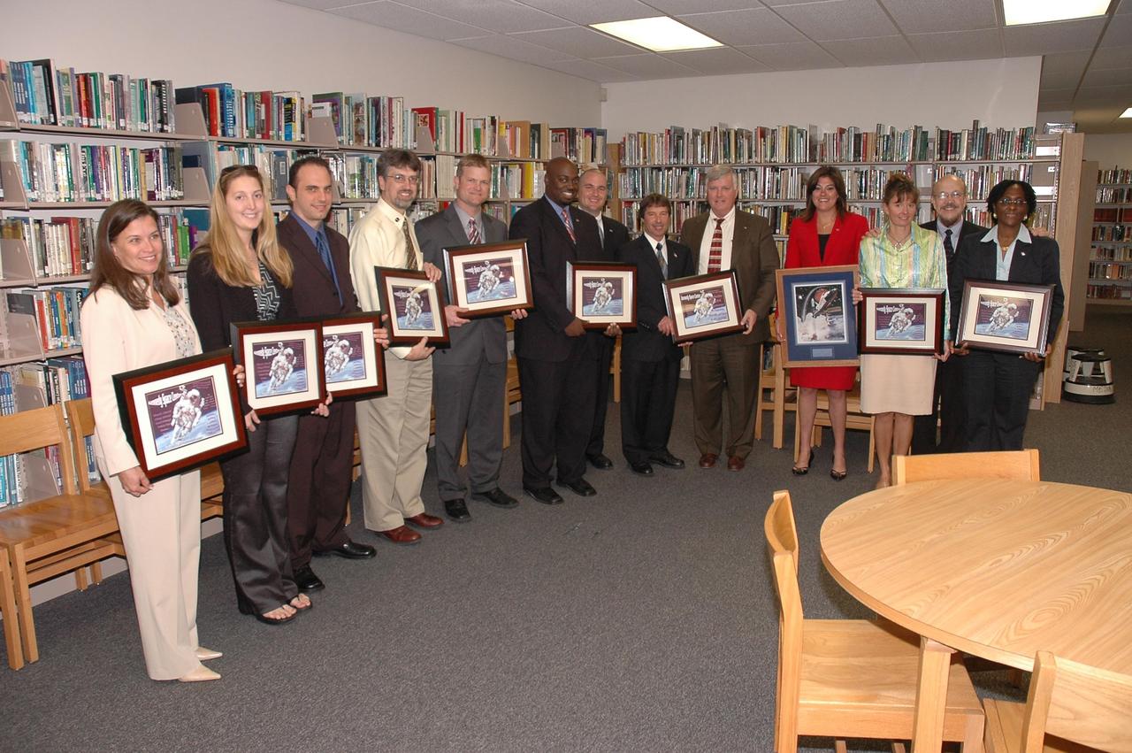 KENNEDY SPACE CENTER, FLA. - The NASA Explorer School (NES) team at Kennedy Space Center poses with the NES team at South Plantation High School in Plantation, Fla.  Center Director Jim Kennedy is fifth from the right.  On the far right is Hortense Burt, with the Education Office at Kennedy.  The Kennedy team, which also included astronaut Roger Couch, is visiting the school to share the vision for space exploration with the next generation. During the visit, Crouch is talking with students about our destiny as explorers, NASA's stepping stone approach to exploring Earth, the moon, Mars and beyond, how space impacts our lives, and how people and machines rely on each other in space.  The Agency's NES program establishes a three-year partnership annually between NASA and 50 NASA Explorer School teams, consisting of teachers and education administrators from diverse communities nationwide.  Photo credit: NASA/Cory Huston