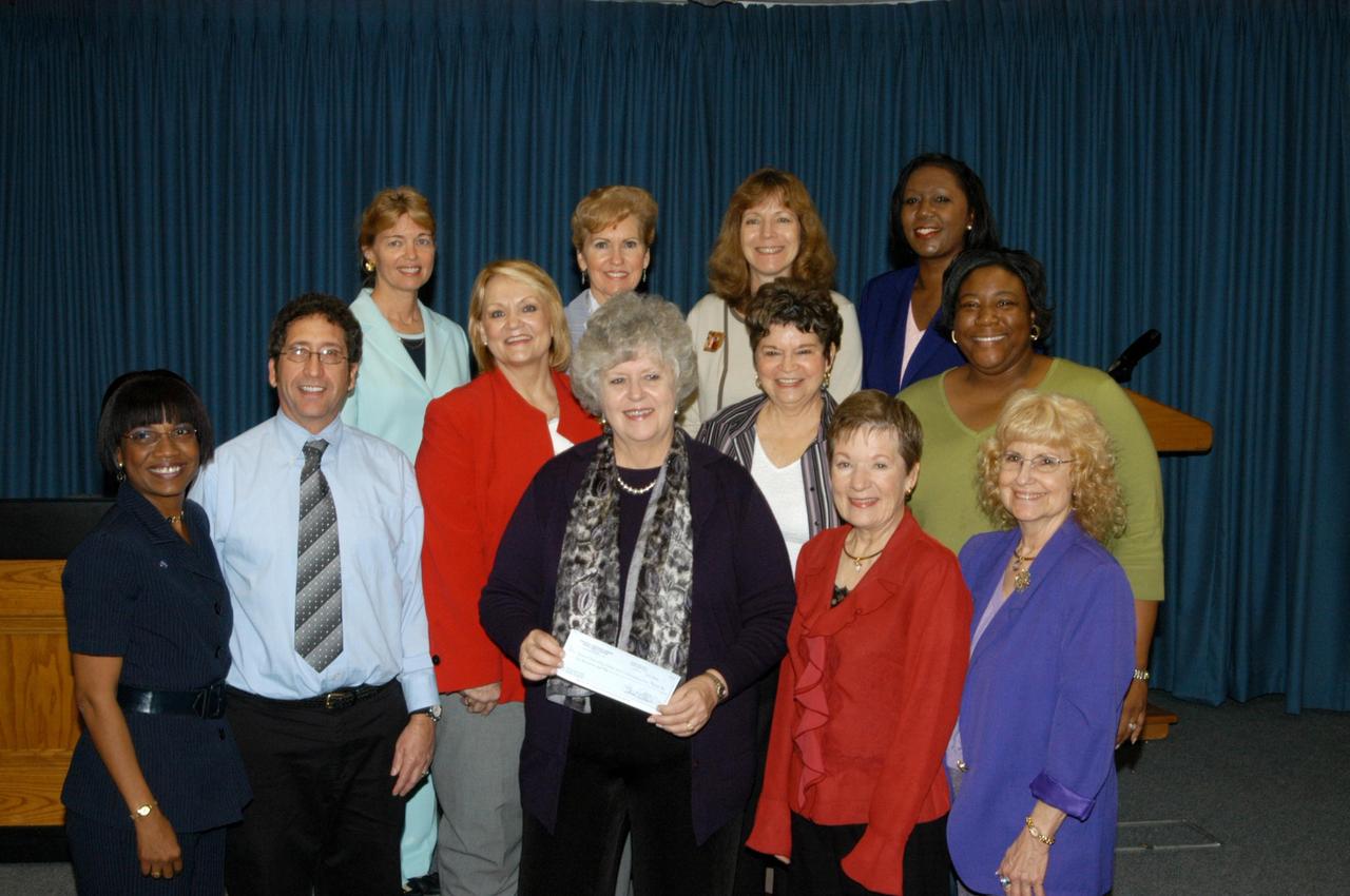 KENNEDY SPACE CENTER, FLA. - Kieta Osteen-Cochrane (front center), executive director of the Institute for Business Training and Community Education at Brevard Community College, holds the check donated to BCC's WENDI program by the Federally Employed Women-Space Coast Chapter at NASA's Kennedy Space Center.  The ceremony was held at Kennedy.  Gathered for the presentation were (front row, left to right) Helen Kane, Richard Belton, Sandra Eliason, Osteen-Cochrane, Jean Grenville, Arden Belt, Charmel Anderson and Carolyn Burnham; (back row) Kathy Roberts, Connie Dobrin, Patty Boatman and Purvette Bryant.  Eliason is president of FEW.  The FEW scholarship committee, chaired by Helen Kane, and the chapter’s Board of Directors, recently voted to contribute their educational scholarship money for 2006 to the WENDI program. This donation amounts to $6,000.  FEW organizes and sponsors conferences and seminars on issues pertinent to women that have benefited not only their members and women at Kennedy Space Center, but throughout all of Brevard.