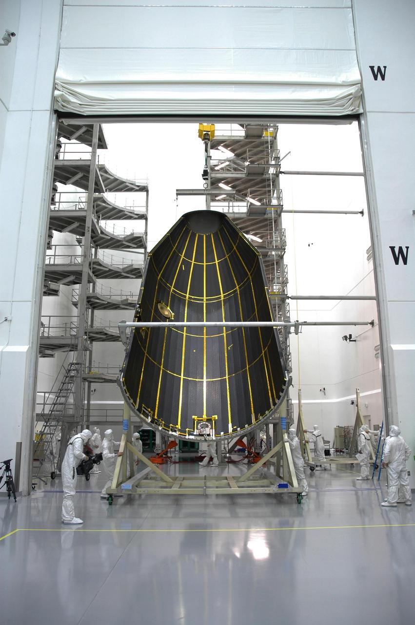 KENNEDY SPACE CENTER, FLA. - At Astrotech Space Operations payload processing facility in Titusville, Fla., one of the fairing halves removed from around the GOES-N spacecraft is being lowered onto a horizontal stand. Removing the fairing will allow workers access to the spacecraft. Workers are using the stand to detach the fairing from around the spacecraft. Workers will use the stand to begin detaching the fairing from around the spacecraft. The fairing protects the spacecraft during launch and flight through the atmosphere. Once out of the atmosphere, the fairing is jettisoned. Removing the fairing will allow workers access to the spacecraft. GOES-N was demated from its Boeing Delta IV launch vehicle when the launch was postponed in August 2005 due to technical issues. Due to the extended length of time the spacecraft had been atop the Delta IV rocket without launching, the weather satellite was returned to Astrotech for some precautionary retesting and state of health checks. GOES-N is the latest in a series of Geostationary Operational Environmental Satellites for NOAA and NASA providing continuous monitoring necessary for intensive data analysis. Photo credit: NASA/Jim Grossmann