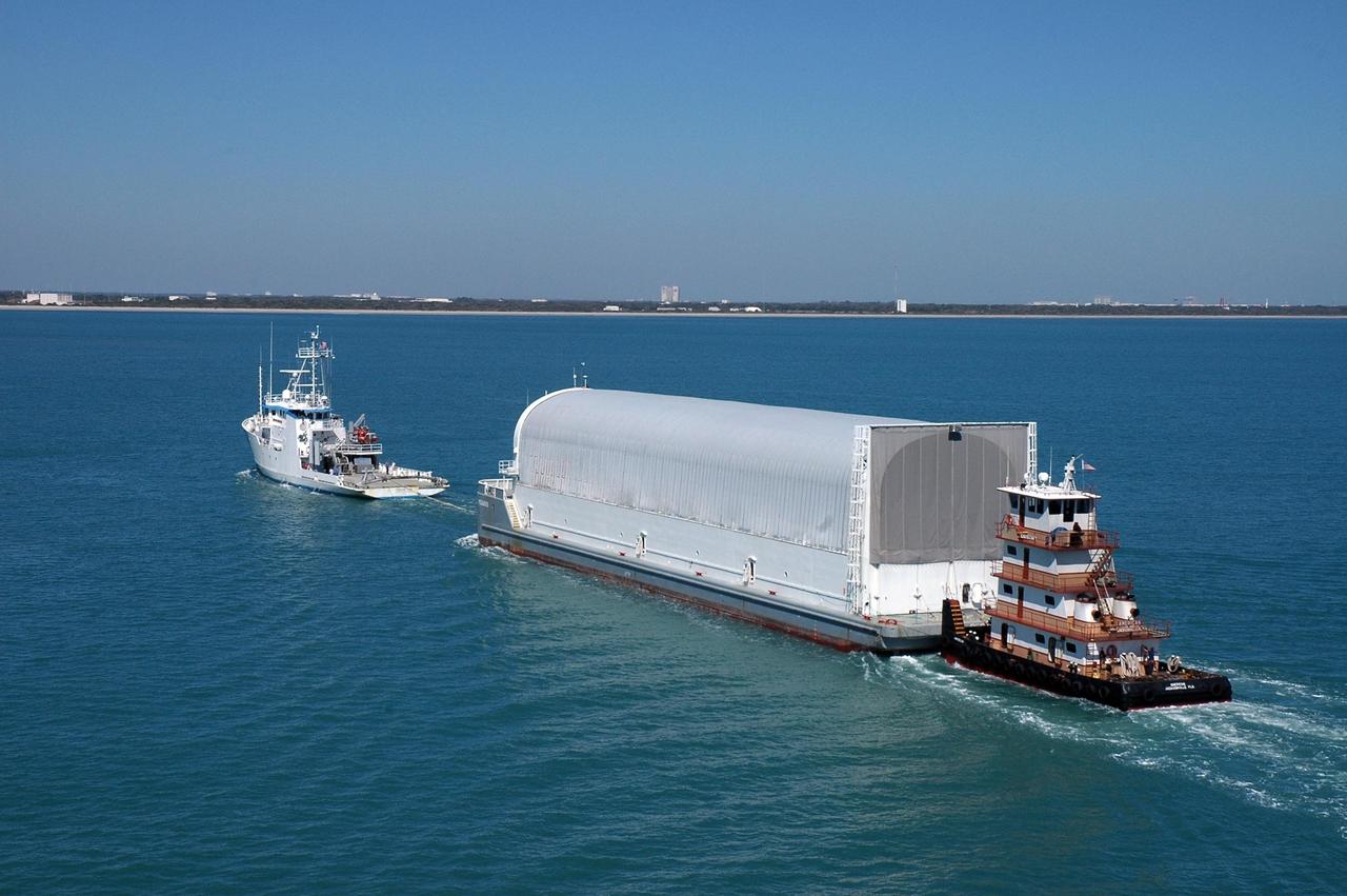 KENNEDY SPACE CENTER, FLA. - The Pegasus barge, towed by the solid rocket booster retrieval ship Freedom Star, approaches Port Canaveral. The barge carries the redesigned external fuel tank that will launch the Space Shuttle Discovery on the next shuttle mission, STS-121. It left the Michoud Assembly Facility in New Orleans Feb. 25, making the voyage around the Florida Peninsula in five days. Next stop for the barge is the turn basin near NASA Kennedy Space Center's Vehicle Assembly Building. After off-loading, the tank will be moved into the Vehicle Assembly Building and lifted into a checkout cell for further work. The tank, designated ET-119, will fly with many major safety changes, including the removal of the protuberance air load ramps. A large piece of foam from one of the ramps came off during the July 2005 launch of the last shuttle mission. The ramps were removed to help eliminate a potential source of damaging debris to the space shuttle. Launch of Discovery is scheduled for May 2006. Photo credit: NASA/Cory Huston