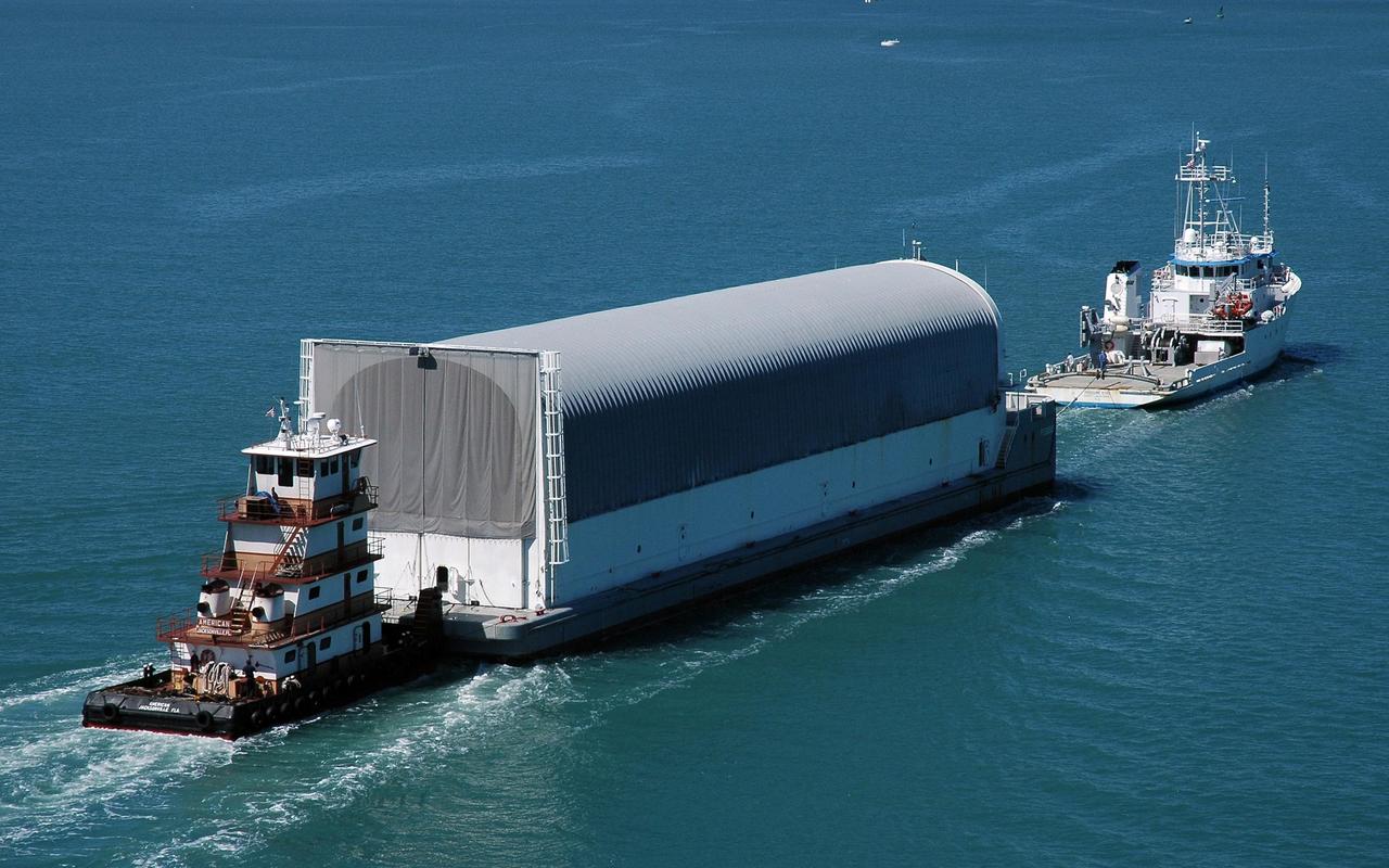 KENNEDY SPACE CENTER, FLA. - The Pegasus barge, towed by the solid rocket booster retrieval ship Freedom Star, approaches Port Canaveral. The barge carries the redesigned external fuel tank that will launch the Space Shuttle Discovery on the next shuttle mission, STS-121. It left the Michoud Assembly Facility in New Orleans Feb. 25, making the voyage around the Florida Peninsula in five days. Next stop for the barge is the turn basin near NASA Kennedy Space Center's Vehicle Assembly Building. After off-loading, the tank will be moved into the Vehicle Assembly Building and lifted into a checkout cell for further work. The tank, designated ET-119, will fly with many major safety changes, including the removal of the protuberance air load ramps. A large piece of foam from one of the ramps came off during the July 2005 launch of the last shuttle mission. The ramps were removed to help eliminate a potential source of damaging debris to the space shuttle. Launch of Discovery is scheduled for May 2006. Photo credit: NASA/Cory Huston
