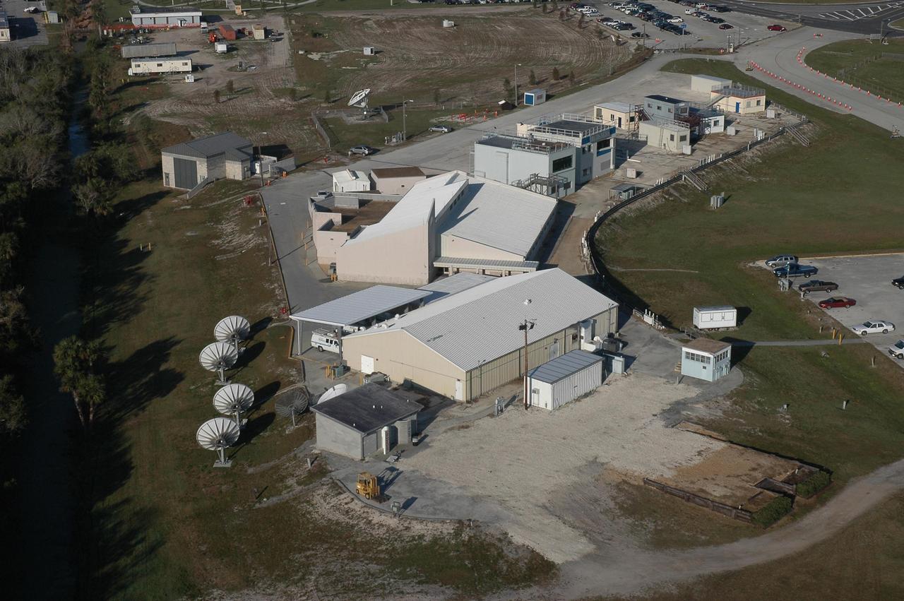 KENNEDY SPACE CENTER, FLA. - This aerial view of the Press Site shows the NASA TV studio (foreground), the NASA News Center behind it, buildings used by local NBC and CBS television stations, and newly erected prefabricated buildings for local newspapers and correspondents for CNN, AP and others. A year-long project removed and replaced hurricane-damaged trailers and grandstands from the site. Photo credit: Cory Huston