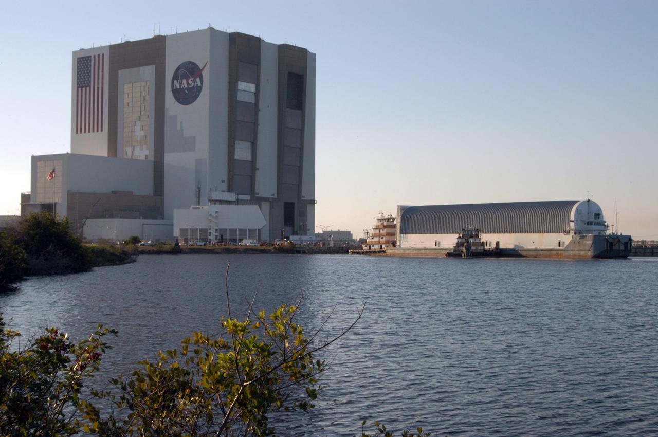 KENNEDY SPACE CENTER, FLA.  - Towed by the solid rocket booster retrieval ship Freedom Star, the Pegasus barge approaches the dock in the turn basin near the Vehicle Assembly Building. The barge is on the last leg of its journey from the Michoud Assembly Facility in New Orleans to NASA's Kennedy Space Center.  The barge carries the redesigned external fuel tank that will launch Space Shuttle Discovery on the next shuttle mission, STS-121.  After off-loading, the tank will be moved into the Vehicle Assembly Building and lifted into a checkout cell for further work. The tank, designated ET-119, will fly with many major safety changes, including the removal of the protuberance air load ramps. A large piece of foam from a ramp came off during the last shuttle launch in July 2005. The ramps were removed to eliminate a potential source of damaging debris to the space shuttle.  The next launch of Discovery is scheduled for May 2006.